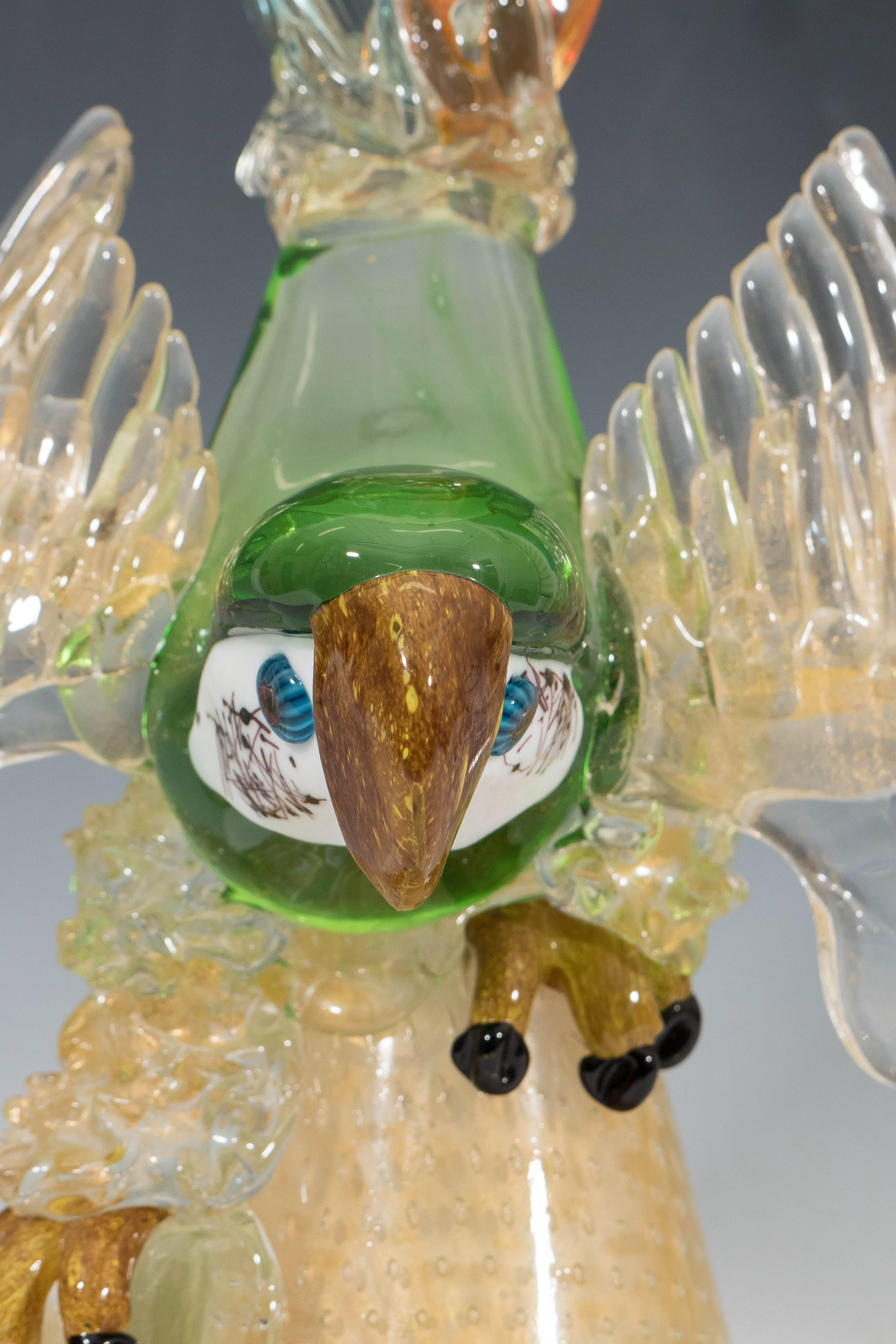 A large sculpture of a parrot, in the style of Barovier e Toso, hand-blown in multicolored Murano glass, with incredibly detailed head, beak and claws. The sculpture is placed on a cone shaped base, with controlled bubbles and infused gold