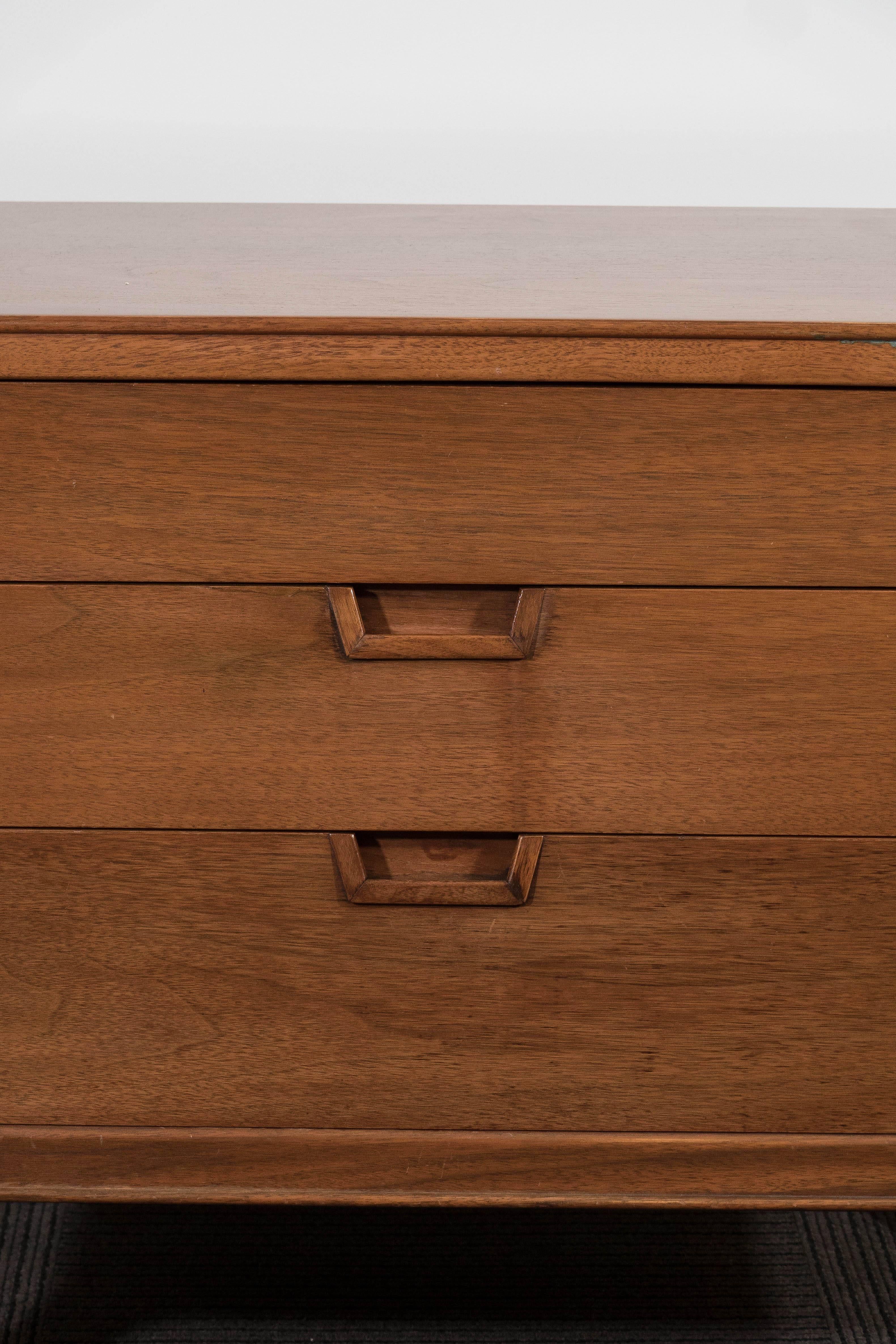 A pair of circa 1960s nightstands and end tables, by designer John Stuart for Janus Collection, in very fine wood, each with drawers, one shallow and two deeper, including recessed pulls. Markings include makers stamp [Mount Airy/Janus Collection]