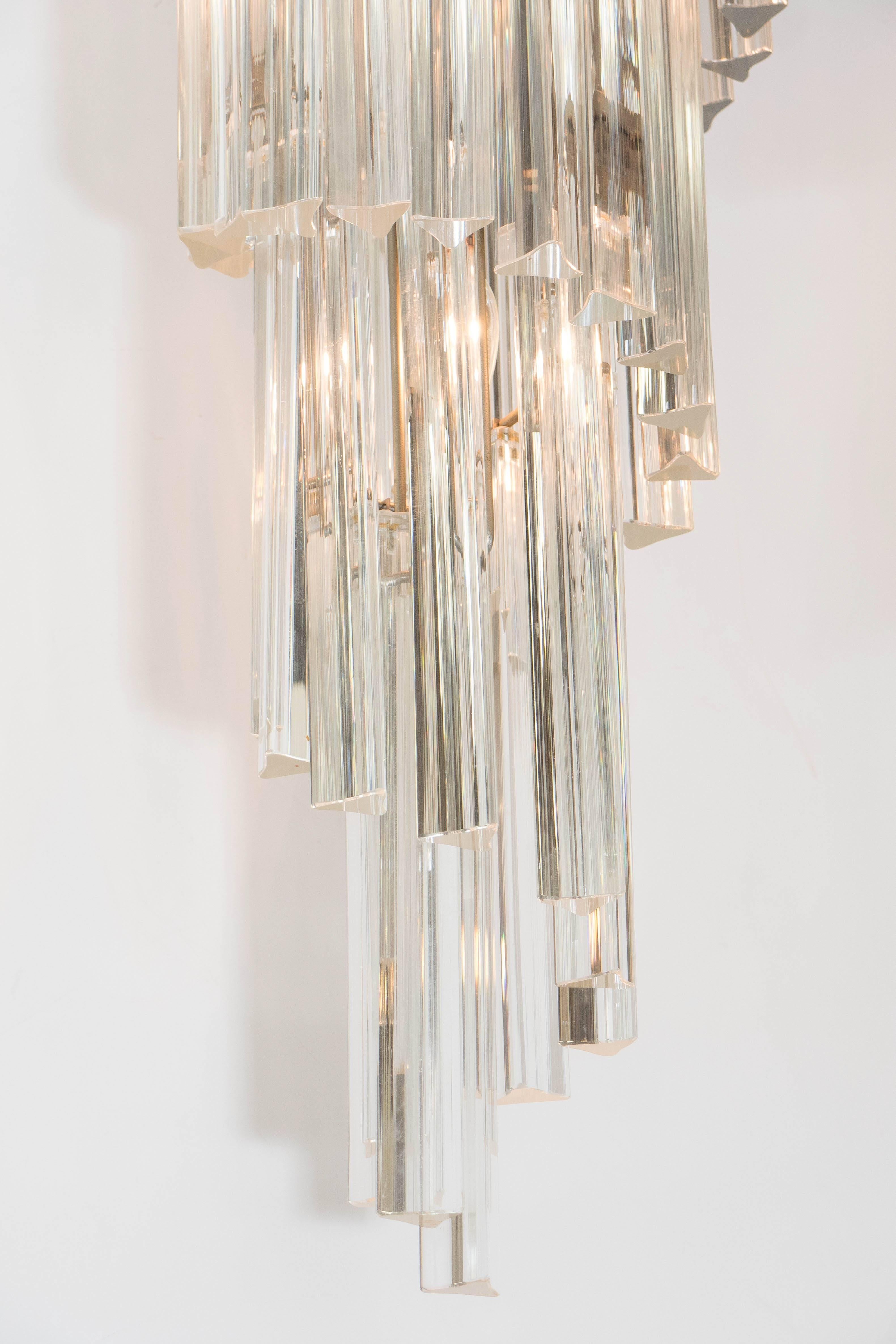 A vintage chandelier, produced in Italy, circa 1960s by Venini, with surrounding Murano glass triedri prisms, suspended from a five-tier brass frame. Wiring and sockets to US standard. Good condition, consistent with age and use, minimal wear to