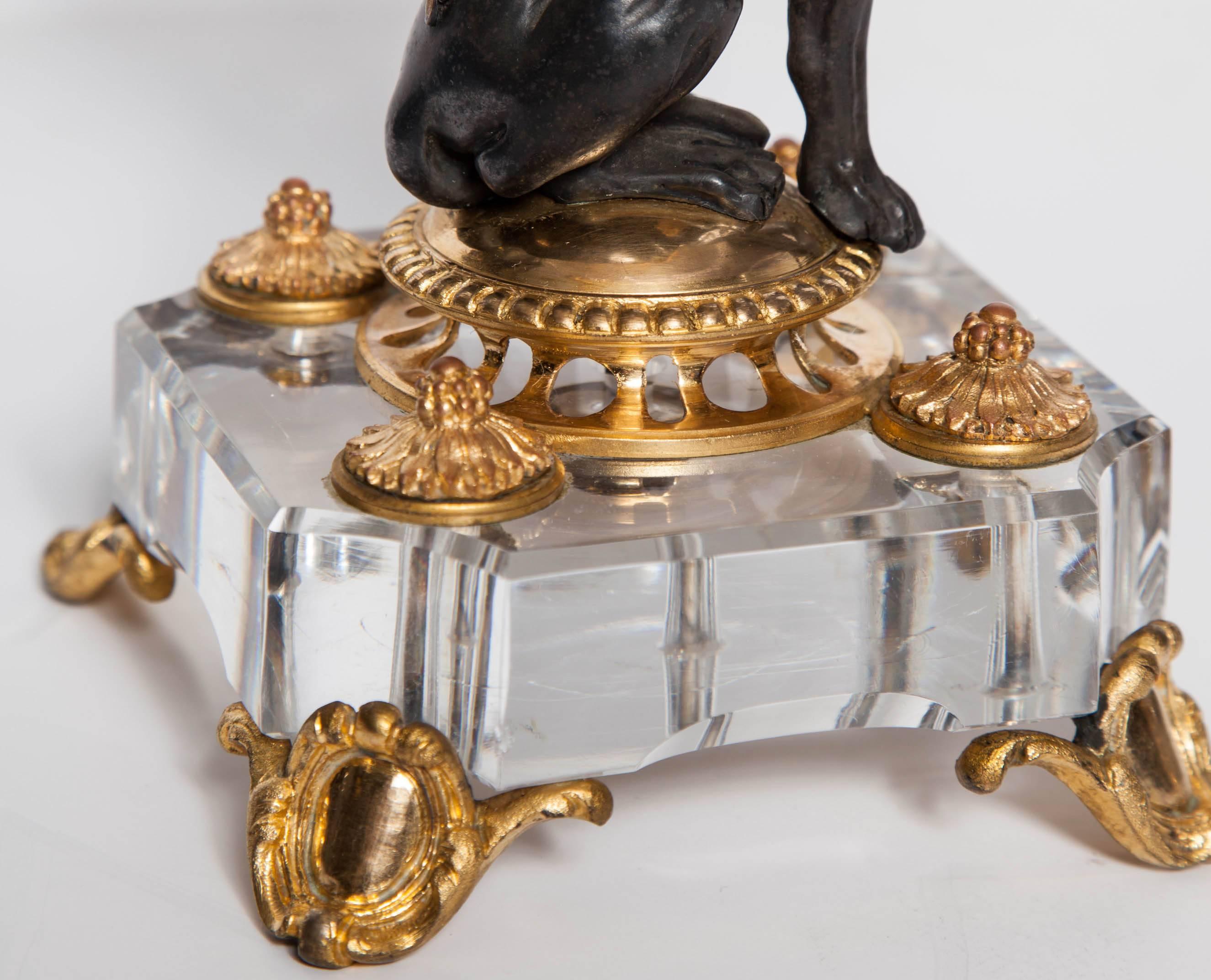 An exceptional pair of antique French signed Baccarat hand diamond cut crystal and two-tone; patinated and doré bronze mounted compotes. Each with a posing bronze lion seated on a square shaped cut crystal pillow, resting on each head an original
