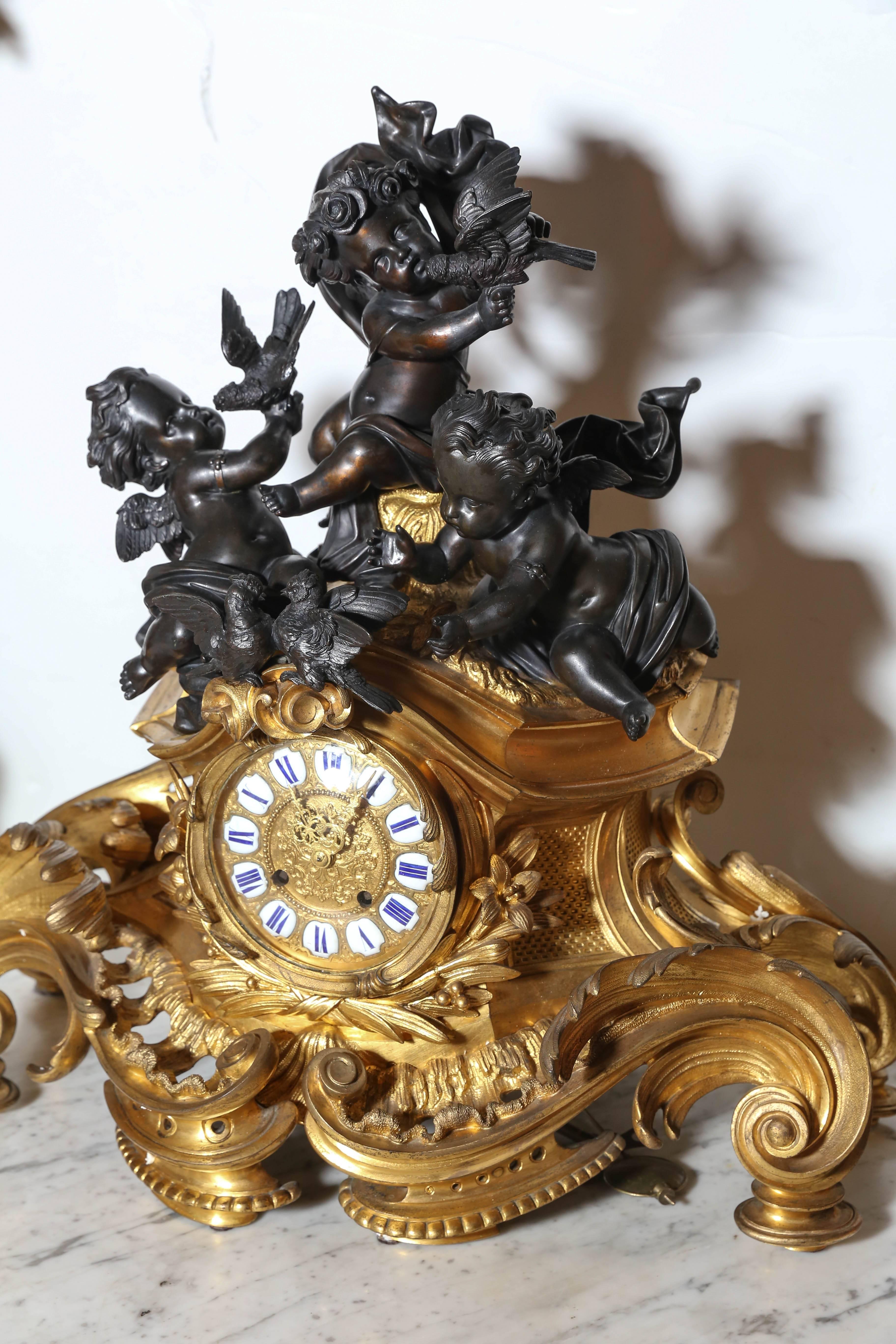 Elaborate gilt bronze Rococo case surmounted by cherubs and birds with
a pair of four-light candelabra. The dial with enameled Roman numeral plaques and the circular brass two-train bell strike movement marked
ringue a Paris 155.