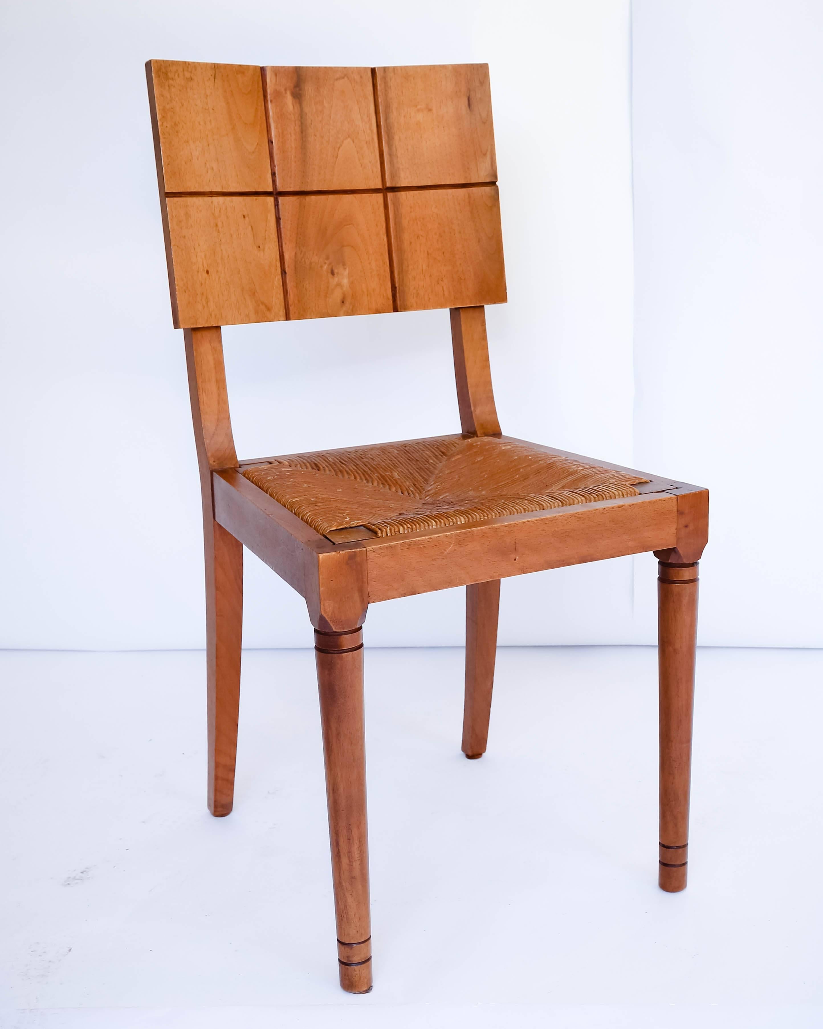 Set of six oak dining chairs with graphic grid design on back rests, and rush seat.