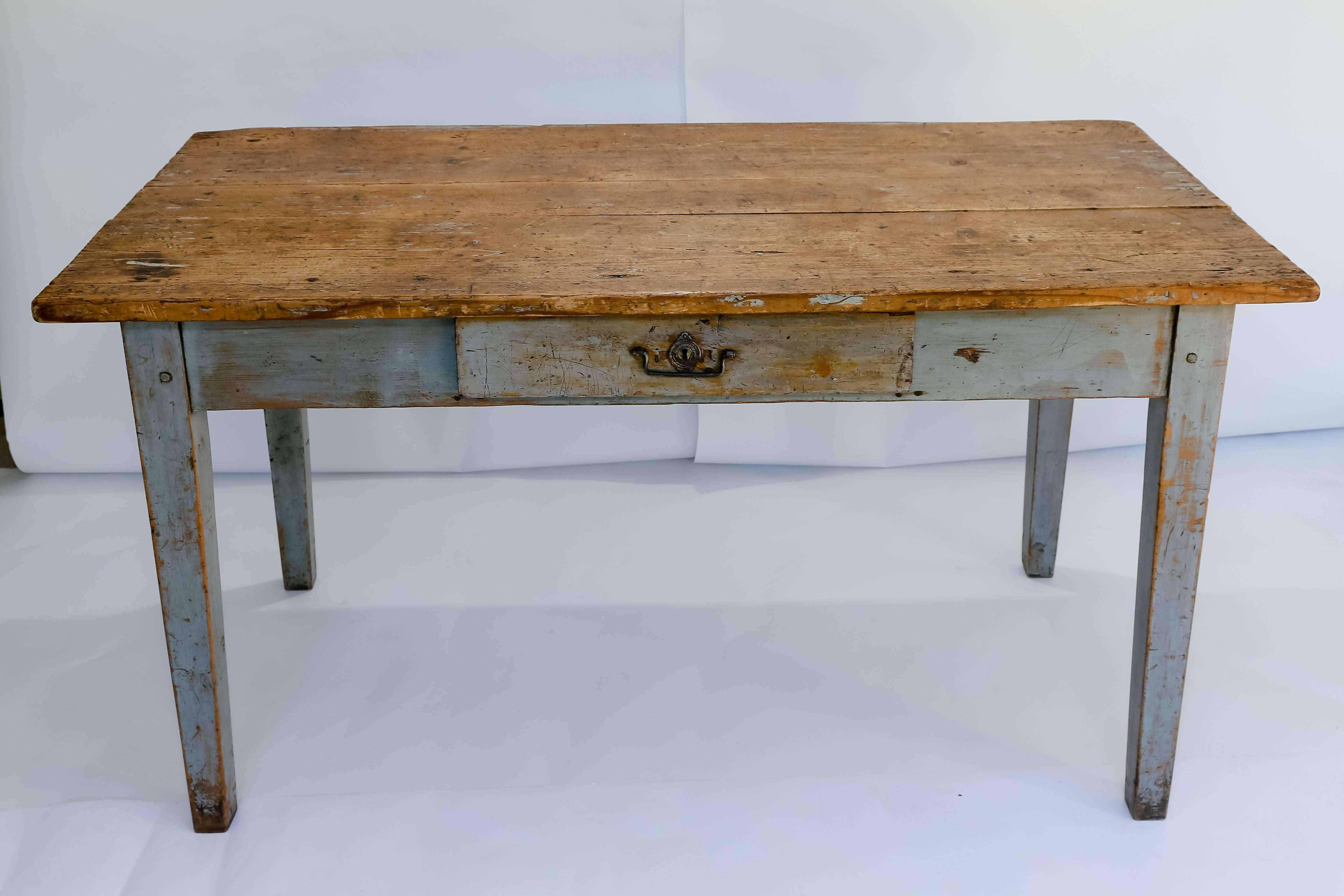 Rustic french farm table or writing desk. Made of beautifully painted wood with an excellent patina. One center drawer with a divided interior and decorative key hole. 