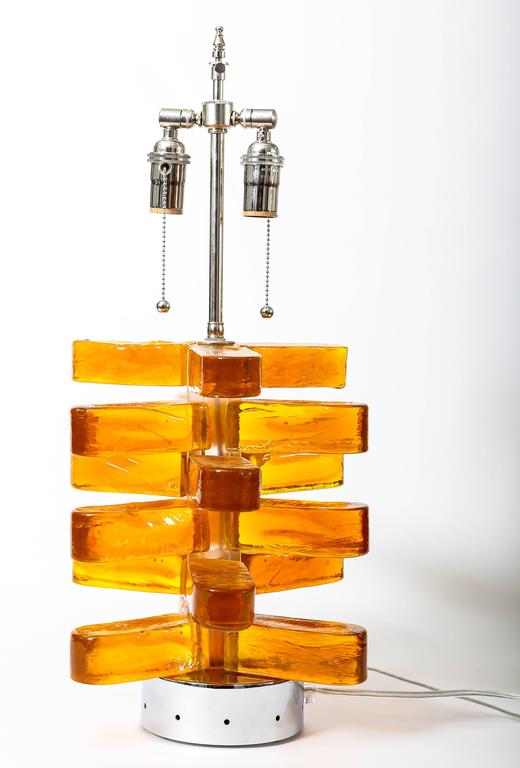 Pair of amber Murano glass lamps featuring interior light with chrome detail.