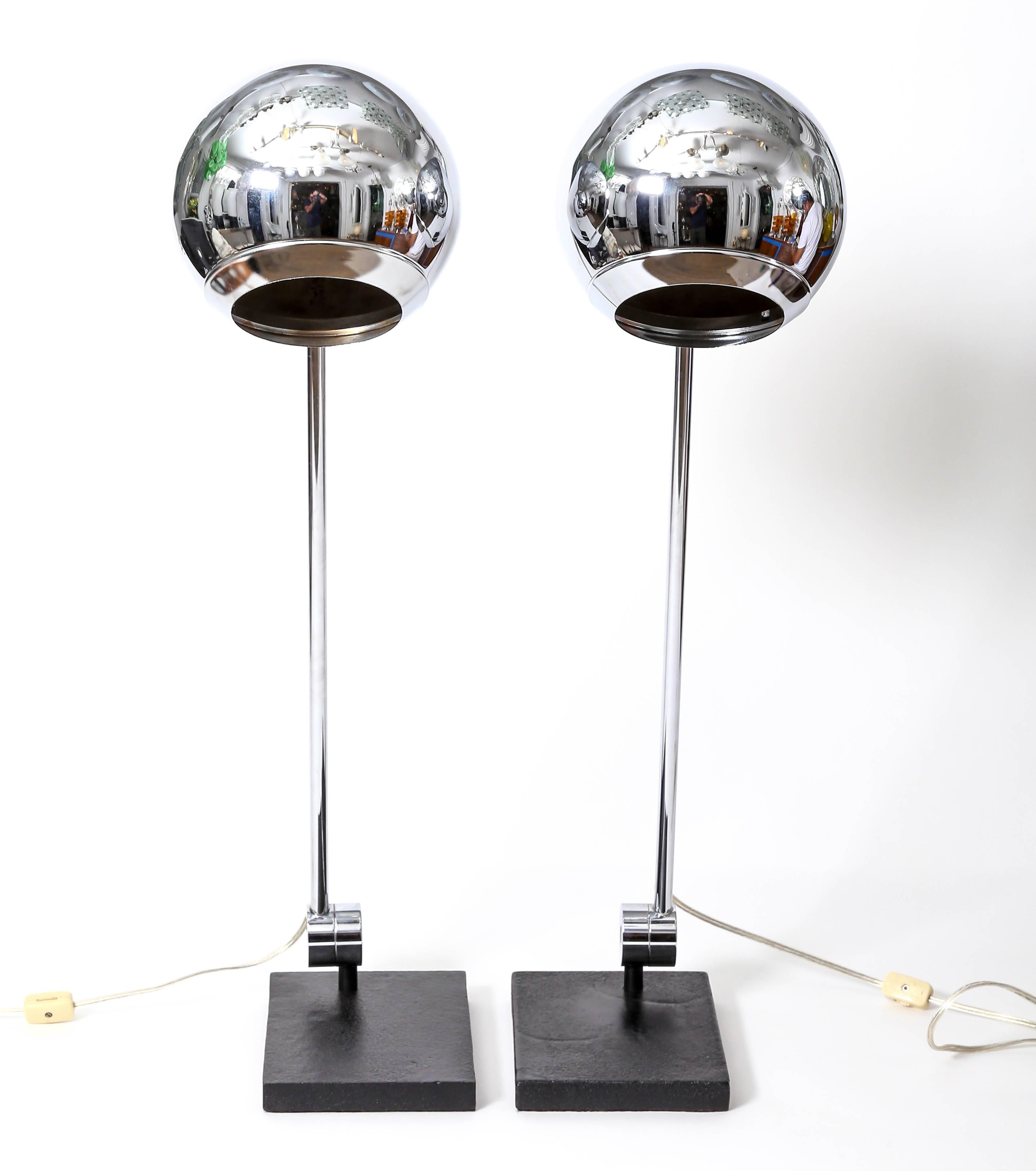 Pair of articulated polished metal orb table lamps with black metal bases by Robert Sonneman.