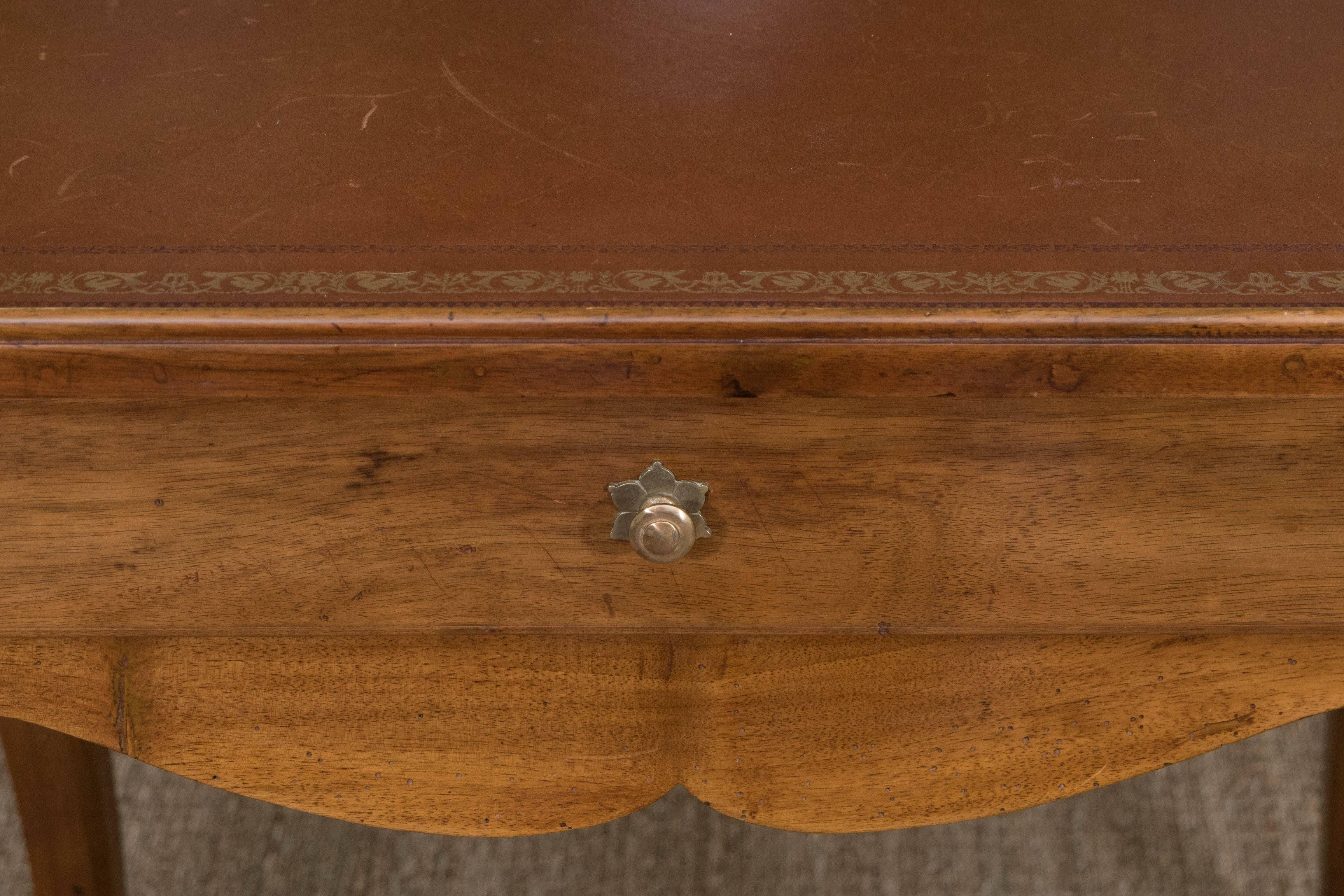 A Louis XV style fruitwood writing table with one drawer and tooled leather top.
