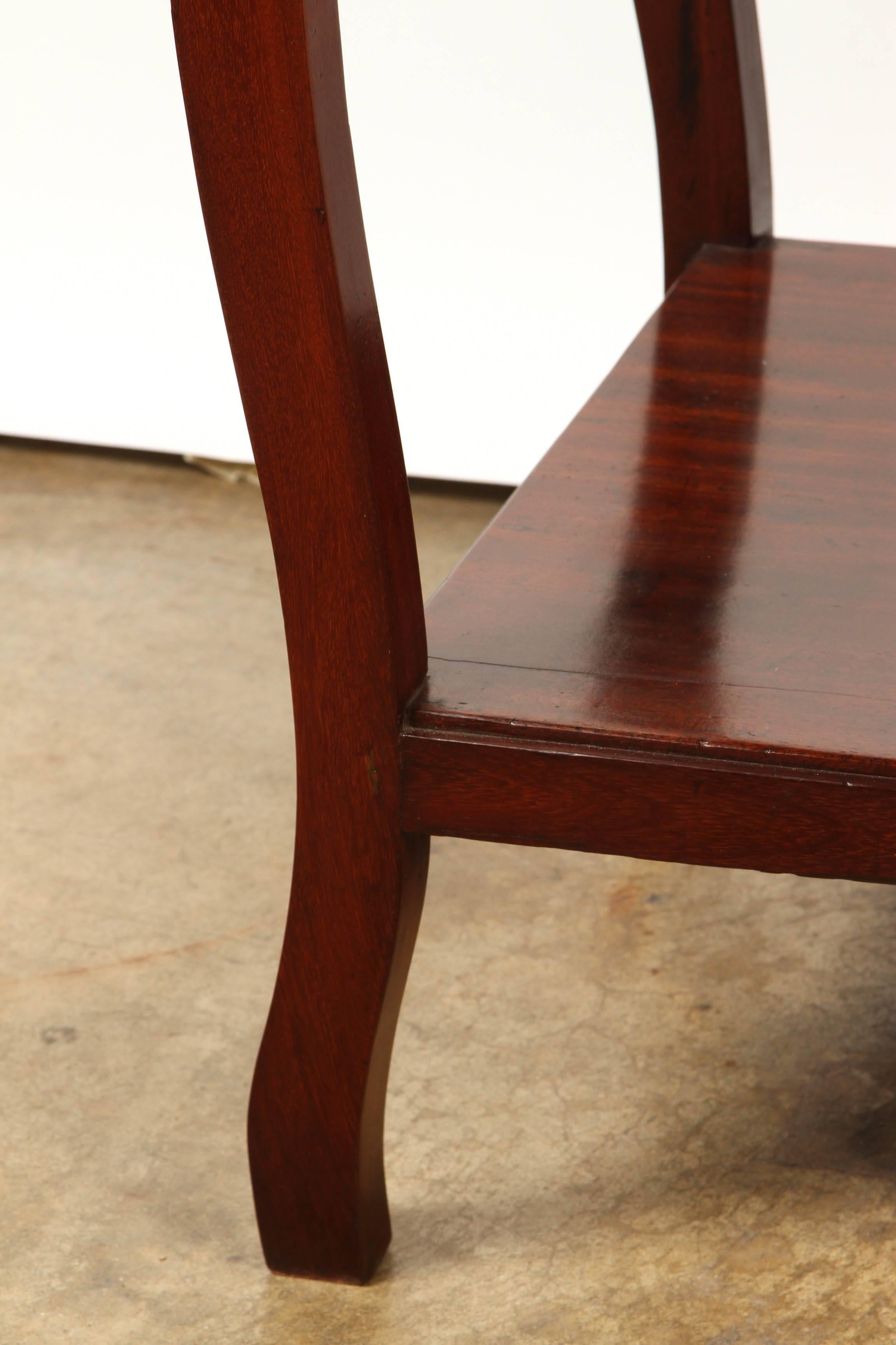 Une table d'appoint coloniale française en bois de rose, qui est simplement construite en bois de rose massif avec un seul tiroir qui a deux tirettes et une étagère en dessous.