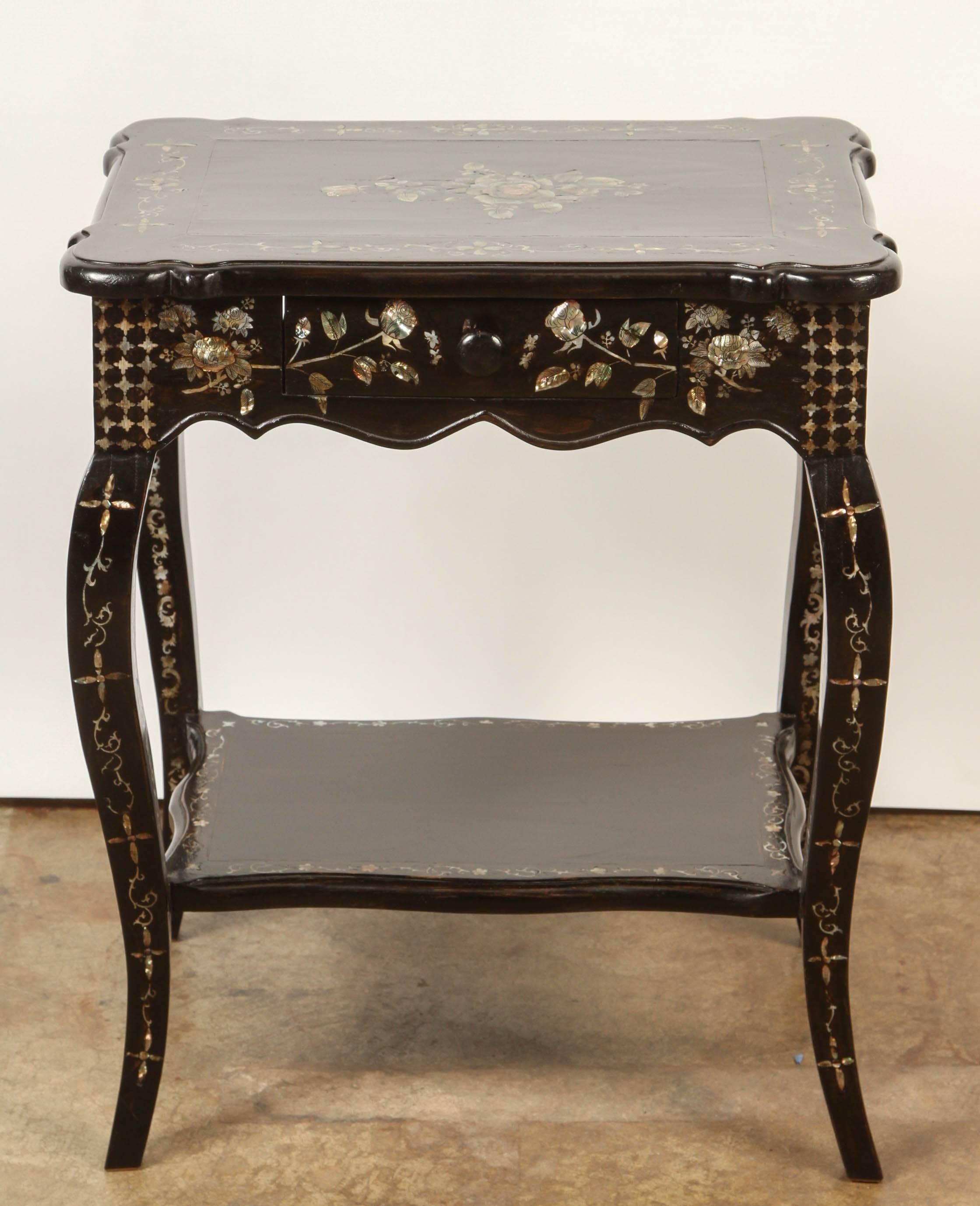 A pair of French Colonial rosewood and mother of pearl side tables, each with four legs that support a single drawer. They are richly inlaid overall with mother of pearl.  These French Colonial side tables were made in Vietnam for the local French