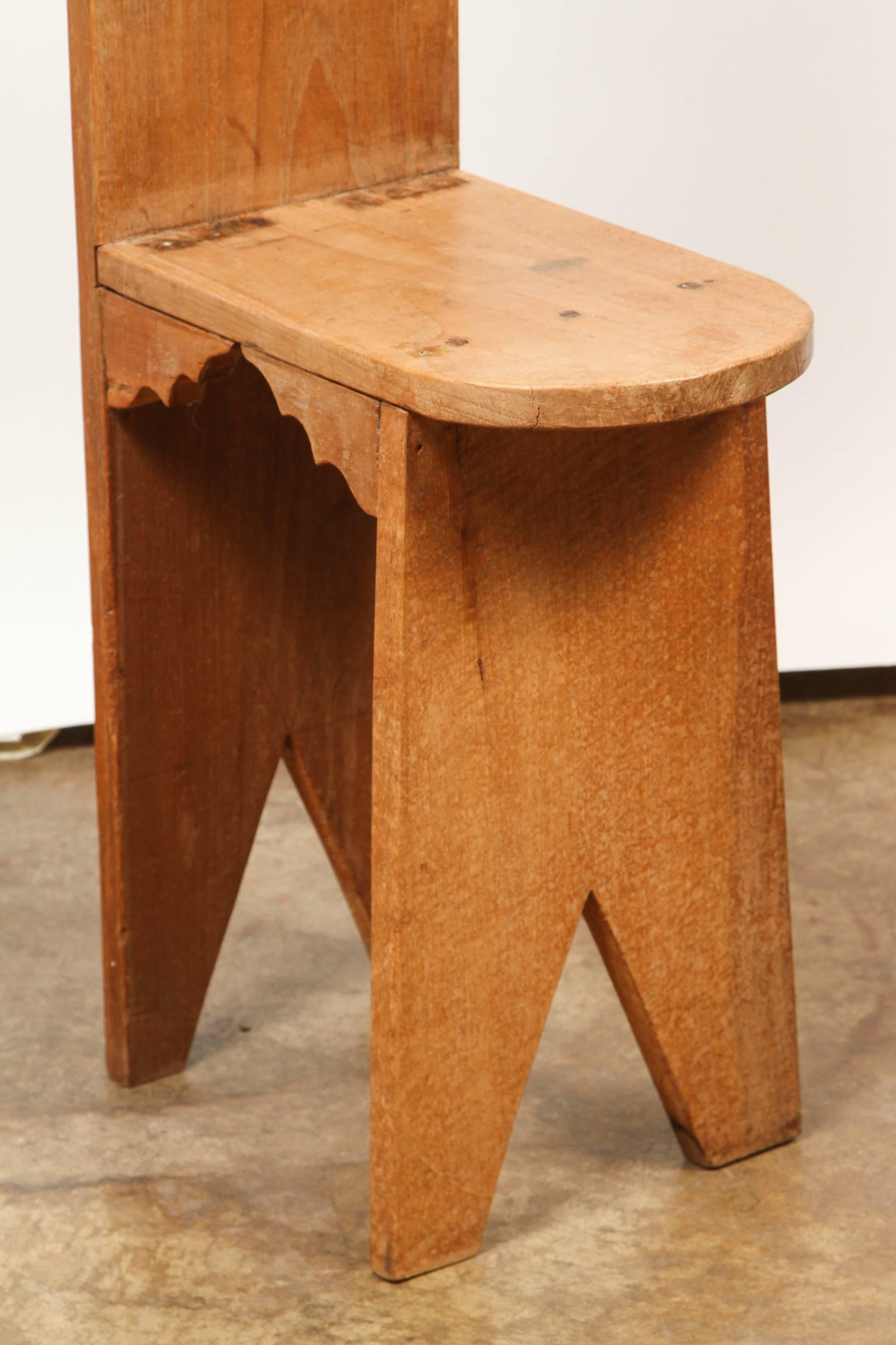 A country Indonesian Highback chair, with simple carved lines and a decorative top