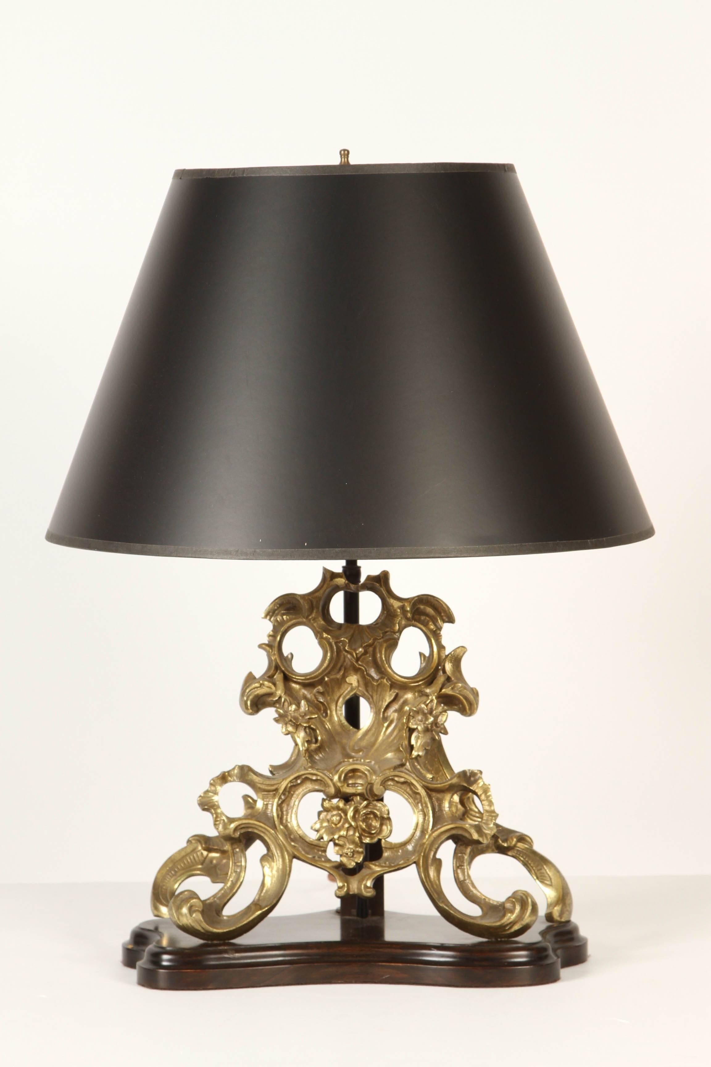 A pair of 19th century French Chenets of solid brass, which are intricately detailed with Rocailles and floral elements. Now fitted as lamps (110w) on custom wood bases.  Sold without shades.