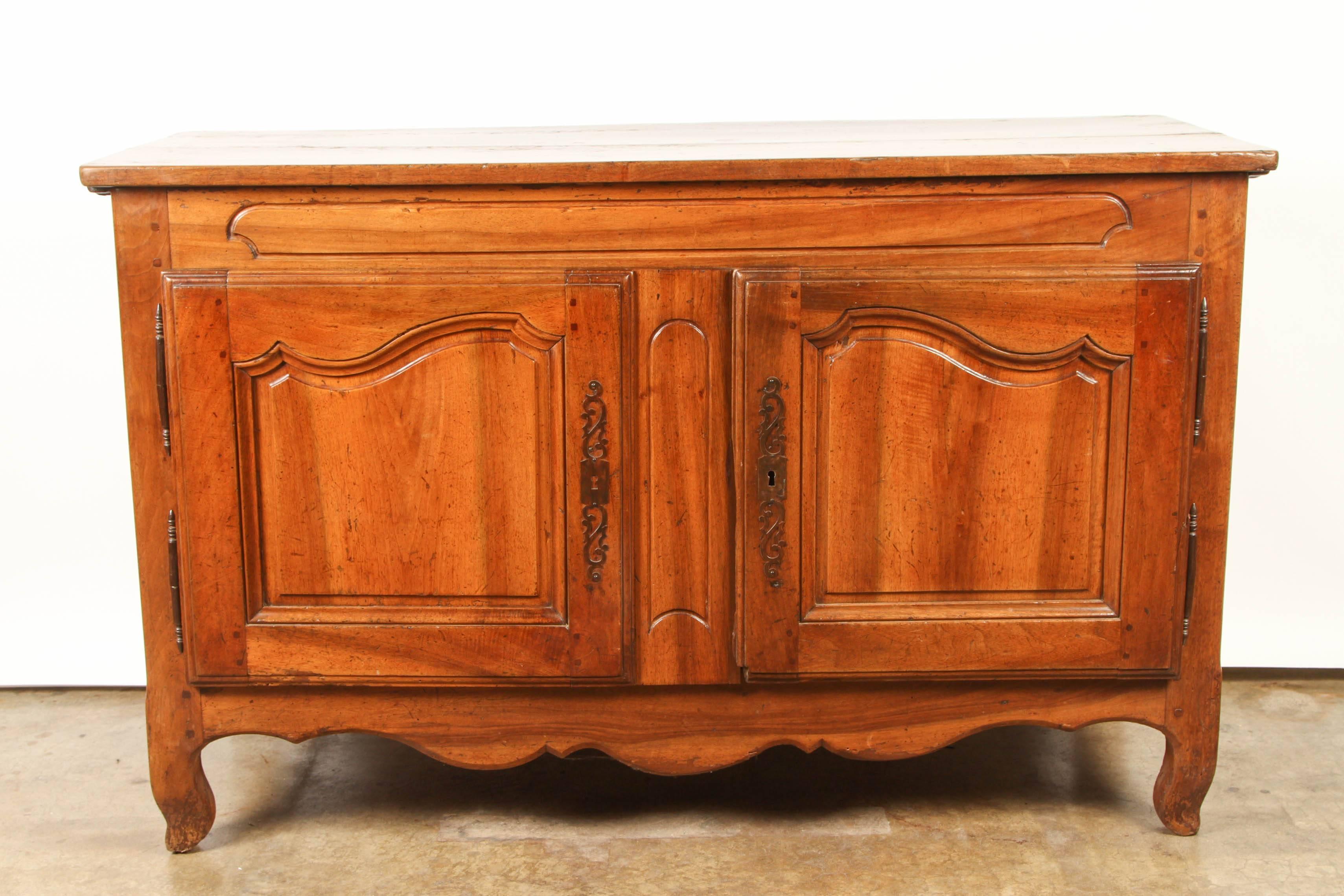 French Provincial Sideboard in walnut. Nice patina overall. Two inset doors open to a single compartment divided by a singe shelf.