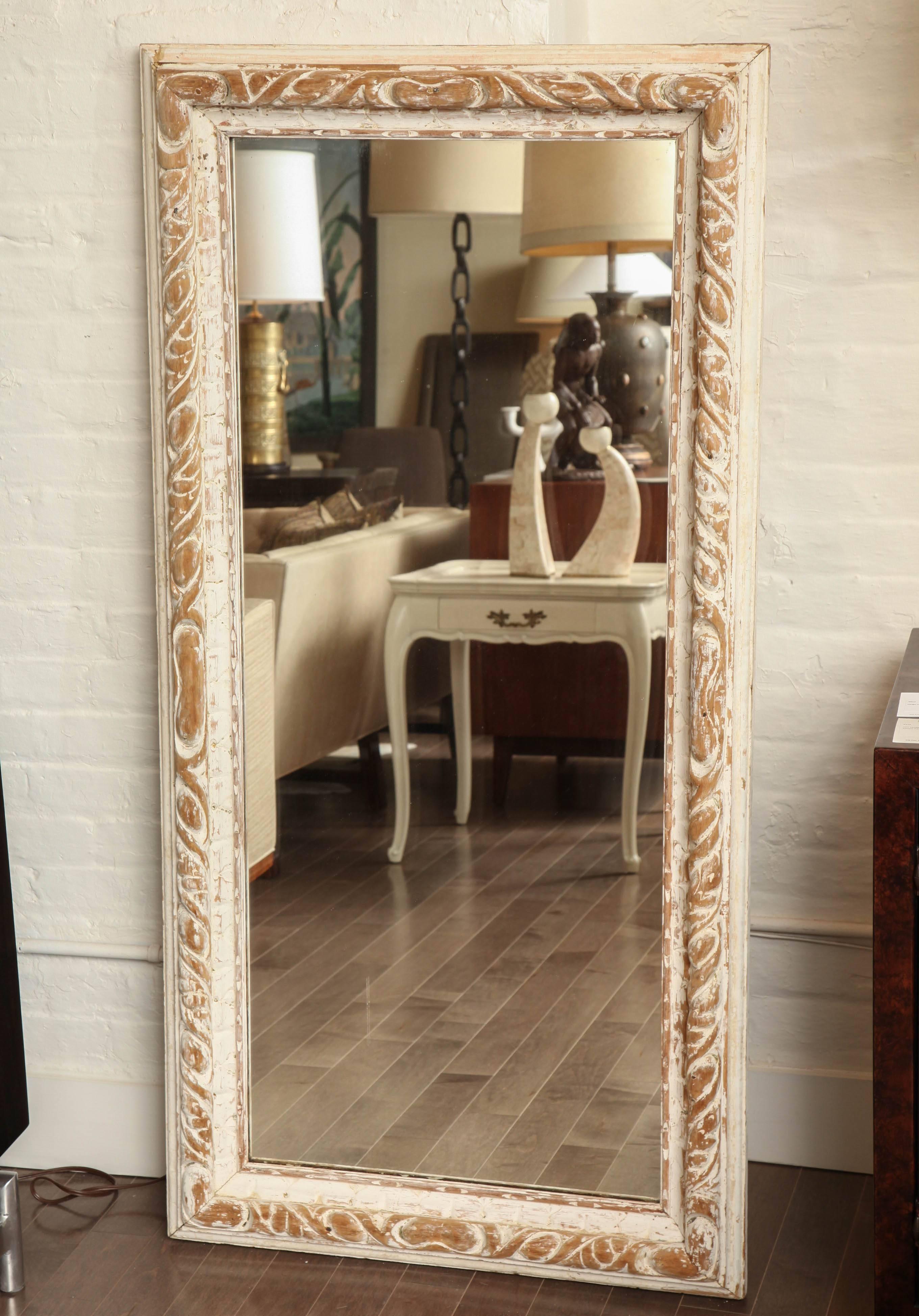 Floor-length mirror in carved worn white painted frame, circa 1950.