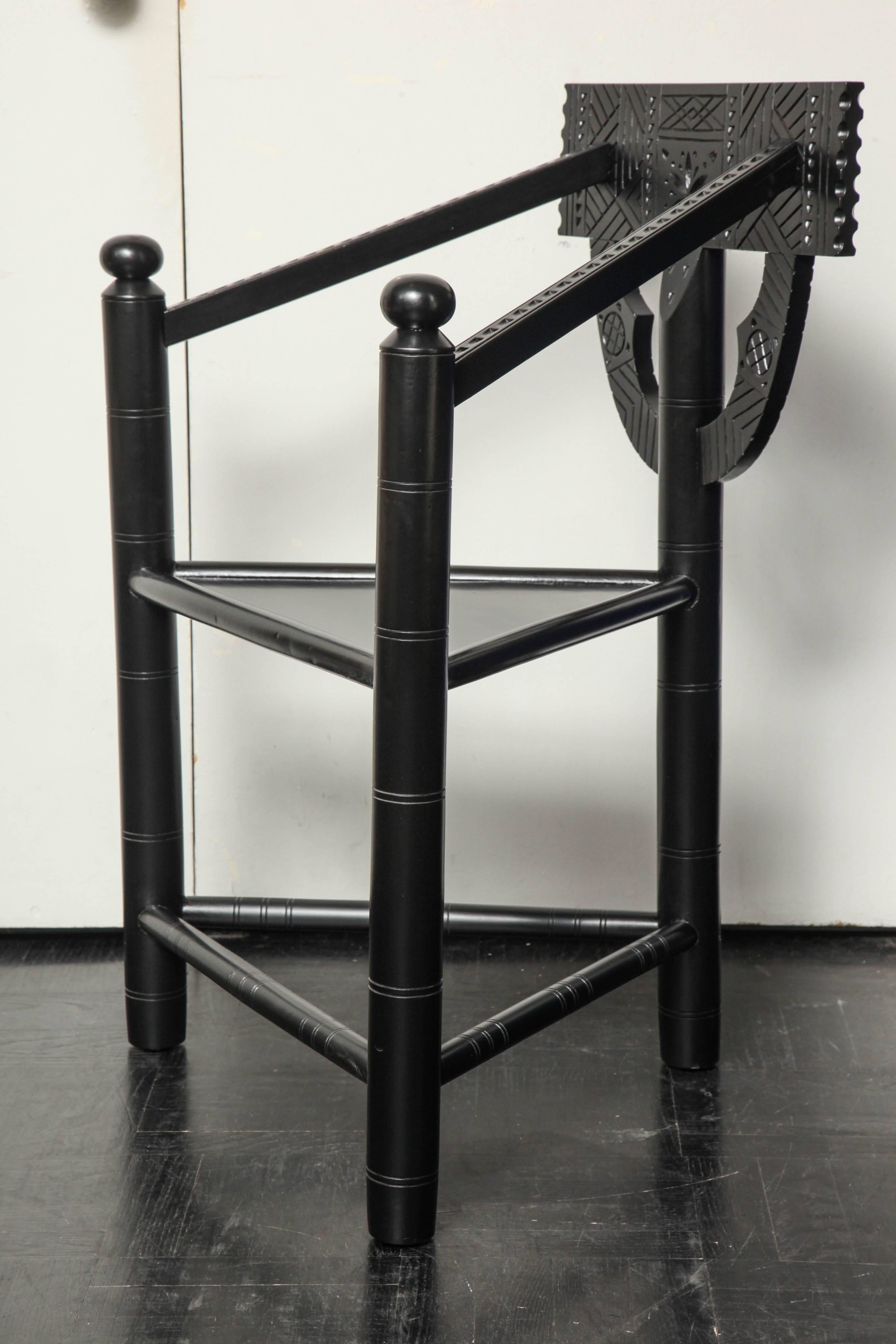19th Century ebonized walnut carved Turner chair with triangular shaped seat, turned spindle back, arms and apron