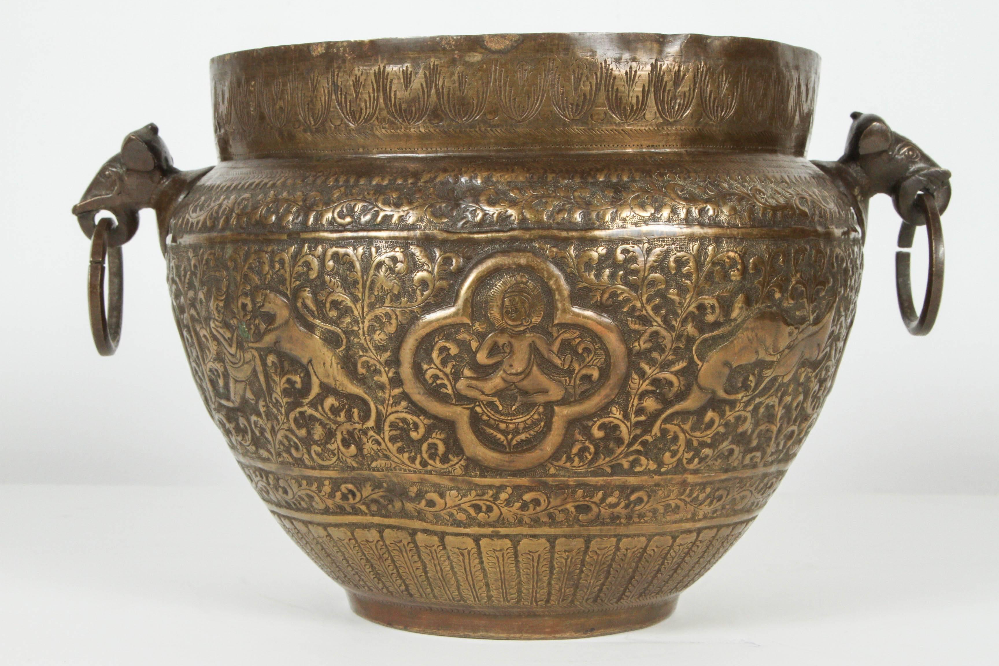 19th century bronze Anglo Indian Mughal style bronzed cache pot.
Great patina on hand-crafted and embossed brass with floral Moorish designs, and hunting scenes with lions and deer.
Some medallion figuring Buddha .
The 2 handles figures are