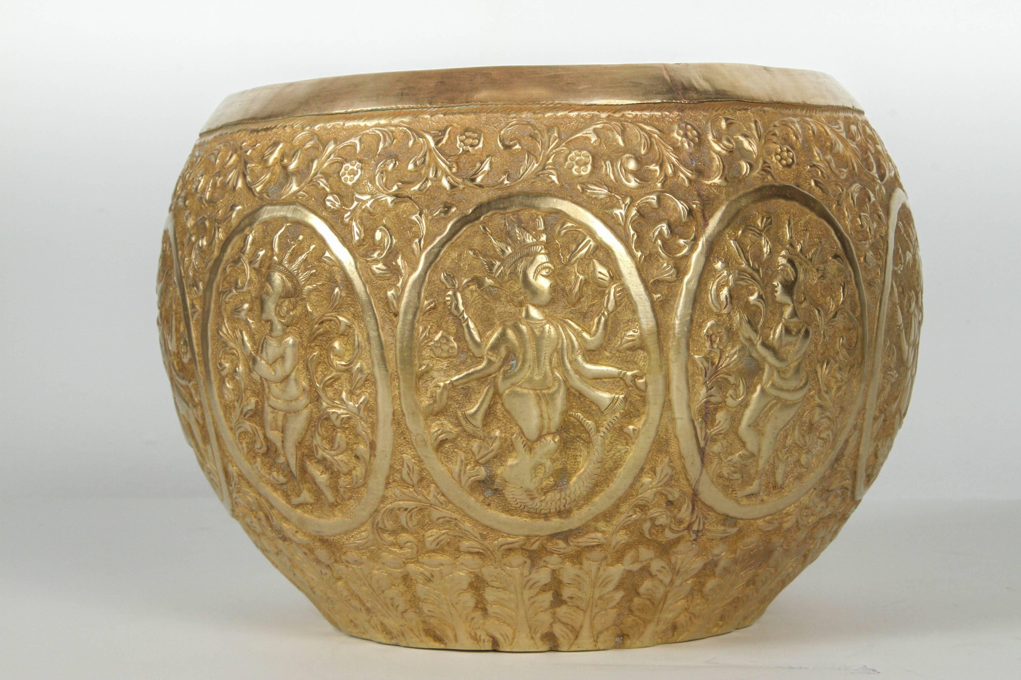 Large polished Indo-Persian brass Jardiniere or cache pot.
Hand etched and hand-embossed by skilled artisan with nice intricate floral designs with medallion of Buddha offering and other Asian Deities.
Fine artwork, museum quality hand-hammered