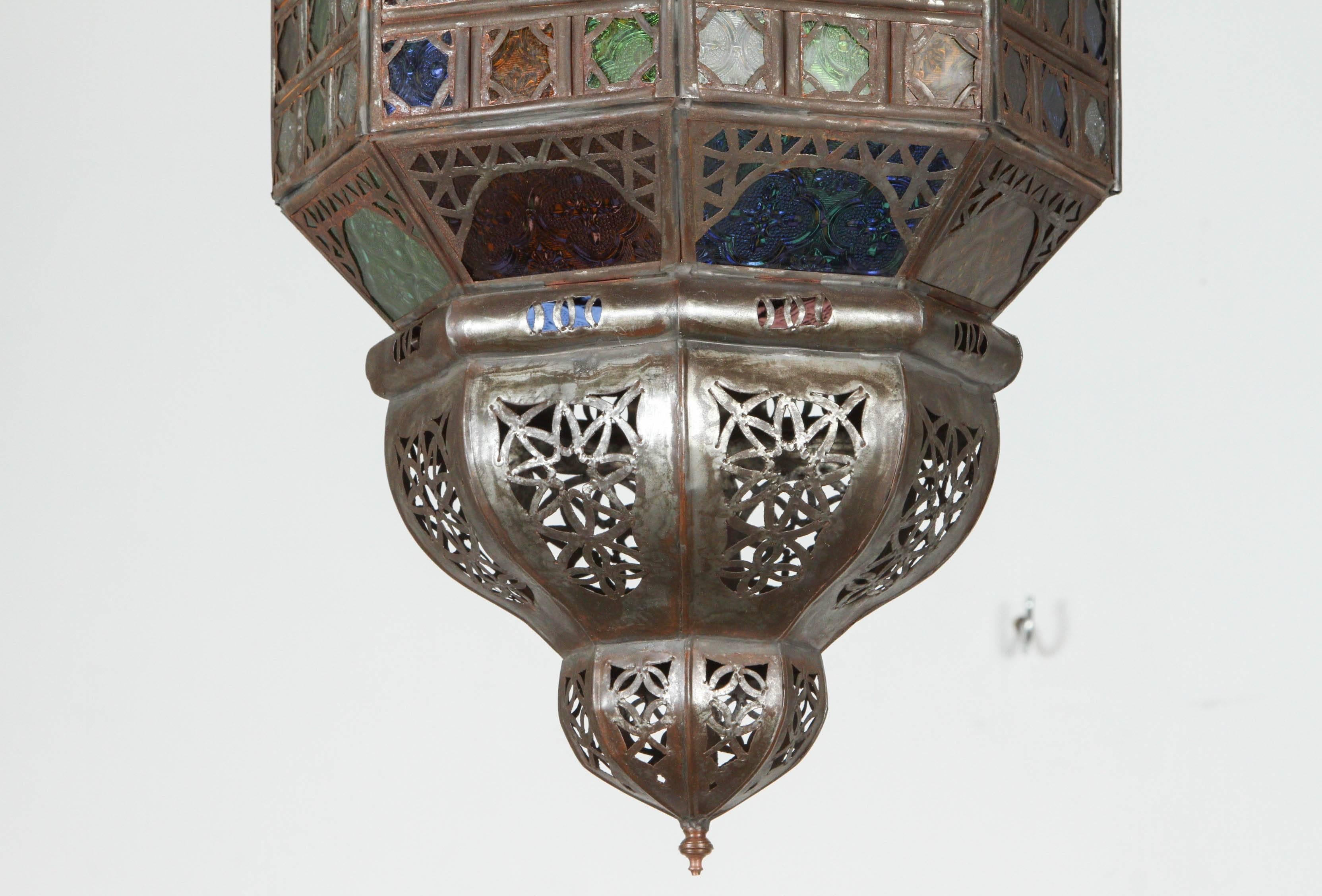 
Handcrafted vintage Moroccan lantern with glass.
Stylish handcrafted Moroccan pendant with multi-color molded stained glass and metal with an antique bronze finish.
Moroccan light fixture with dozen of small cut-glass with Moorish filigree metal