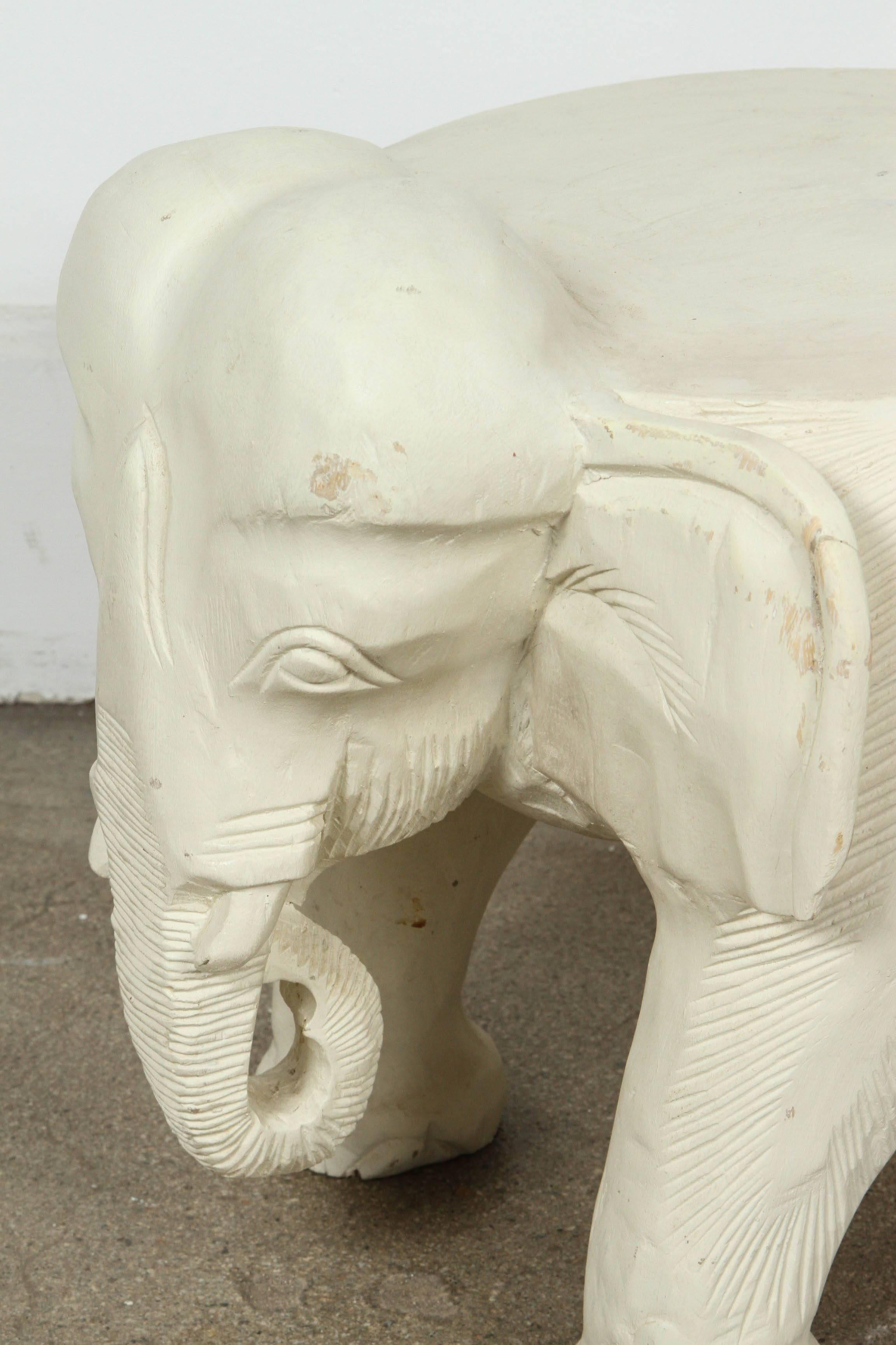 Hand-carved wooden elephant stool, or occasional table, very nice abstract hand-carved on one piece of wood.
Painted in white in Tony Duquette style.
Probably from Thailand