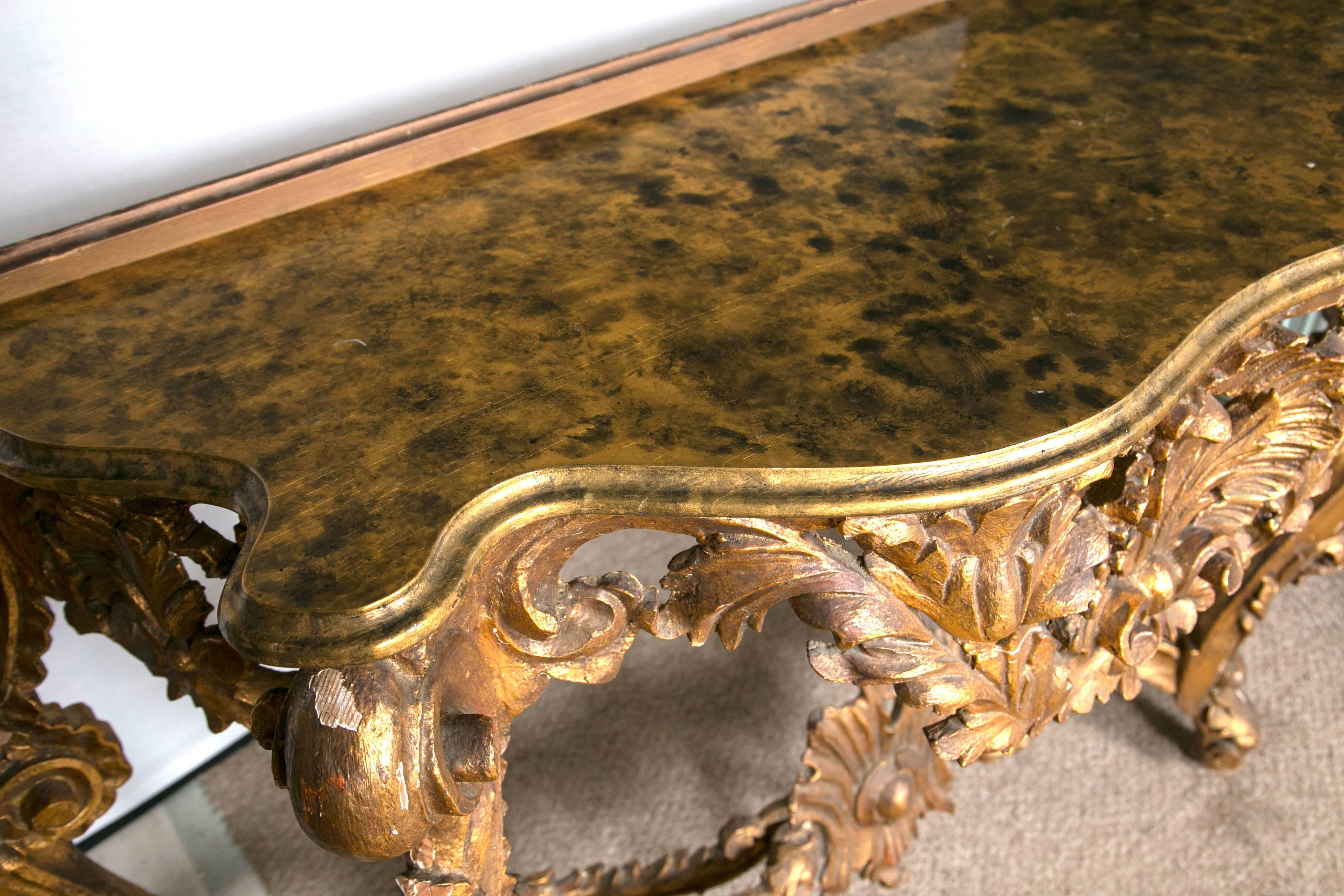 Pair of giltwood consoles with faux marble tops. This pair of giltwood console with faux marble top is a Fine representation of Italy design circa 1750s Rococo period. Exquisite detail. The central carved shell apron leading to a set of giltwood