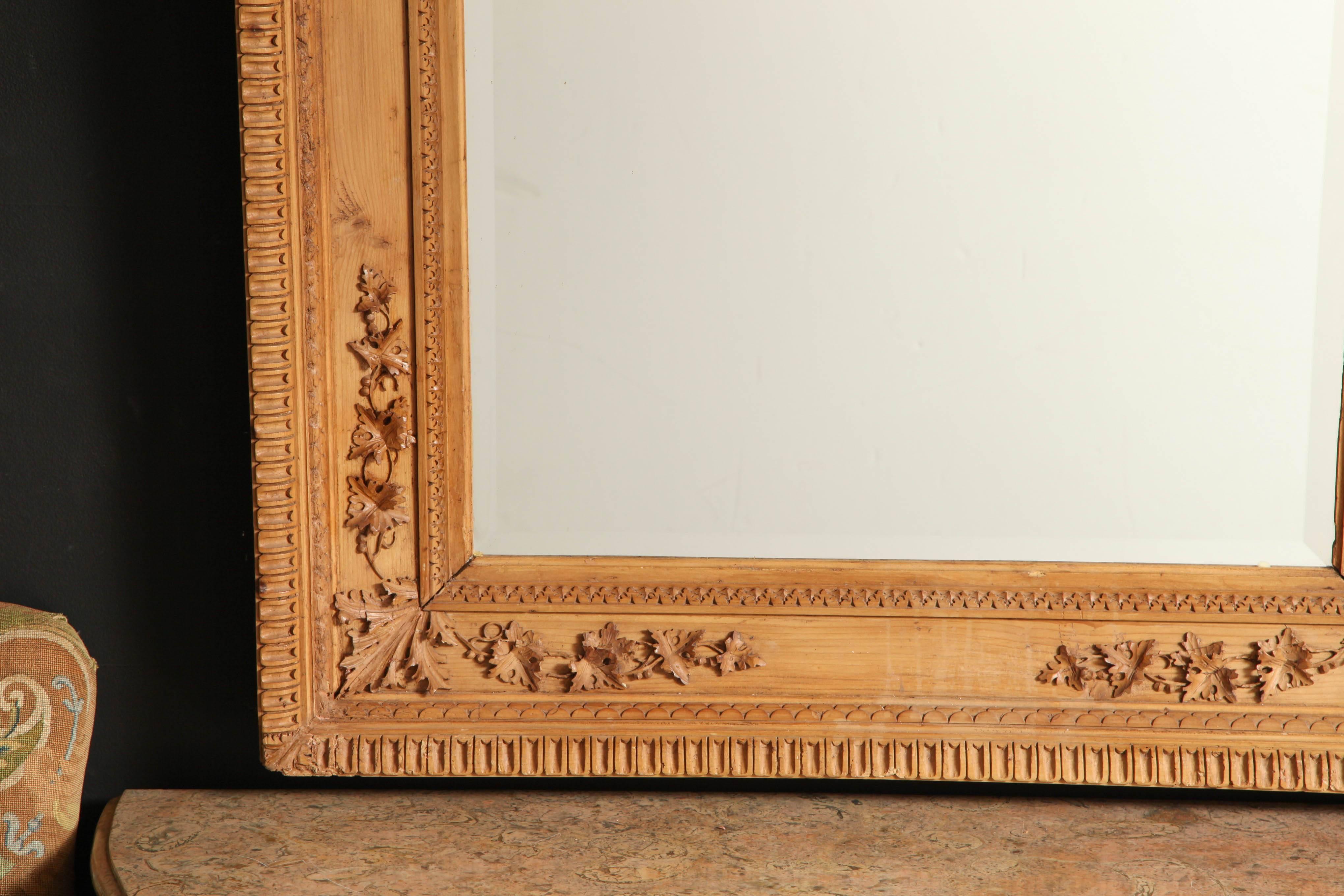 American Aesthetic Movement carved pine mirror with trailing ivy leaf carved corners, and carved inner and outer moldings, with a beveled glass plate.
