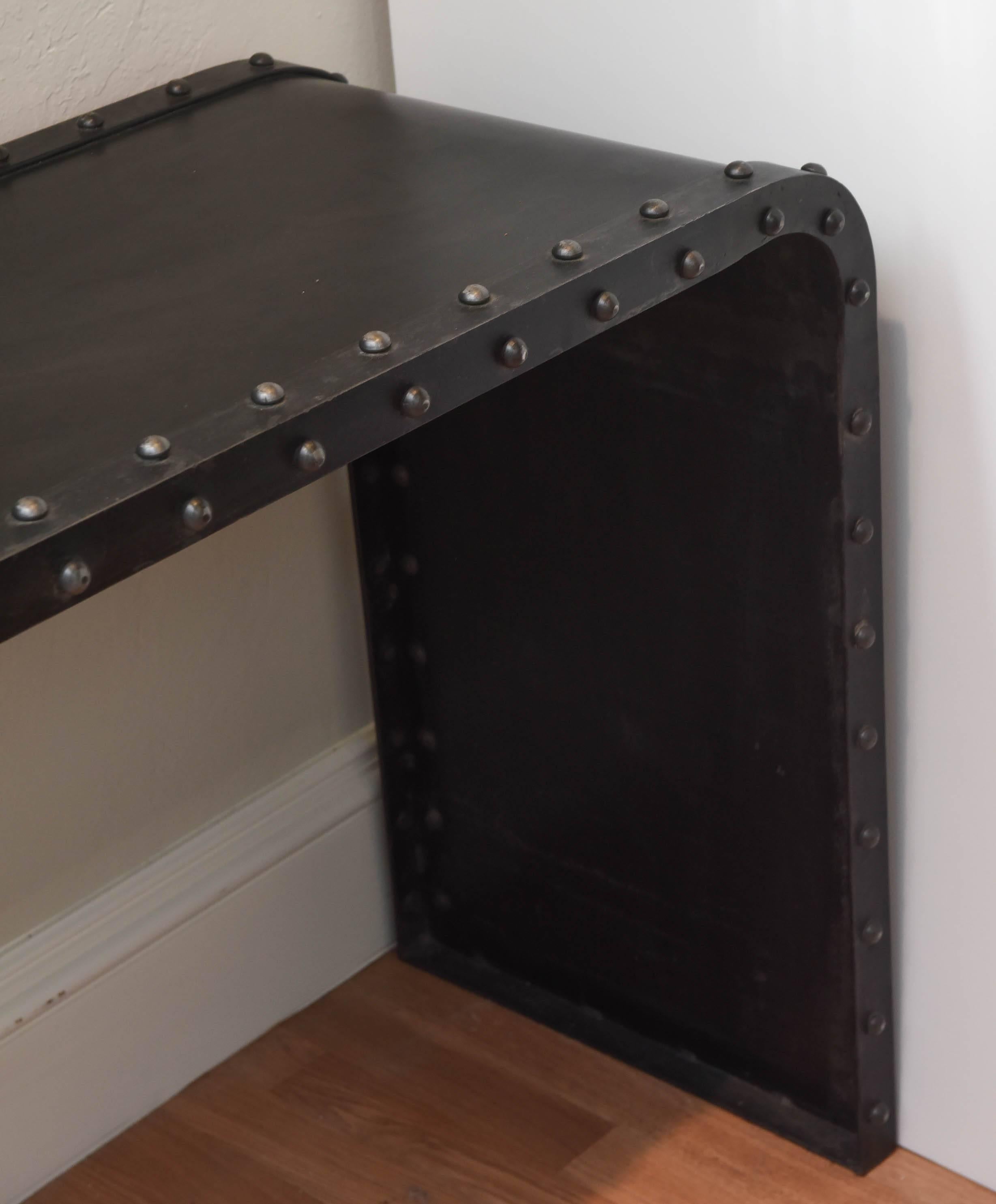 Molded metal console trimmed with iron studded borders.
     