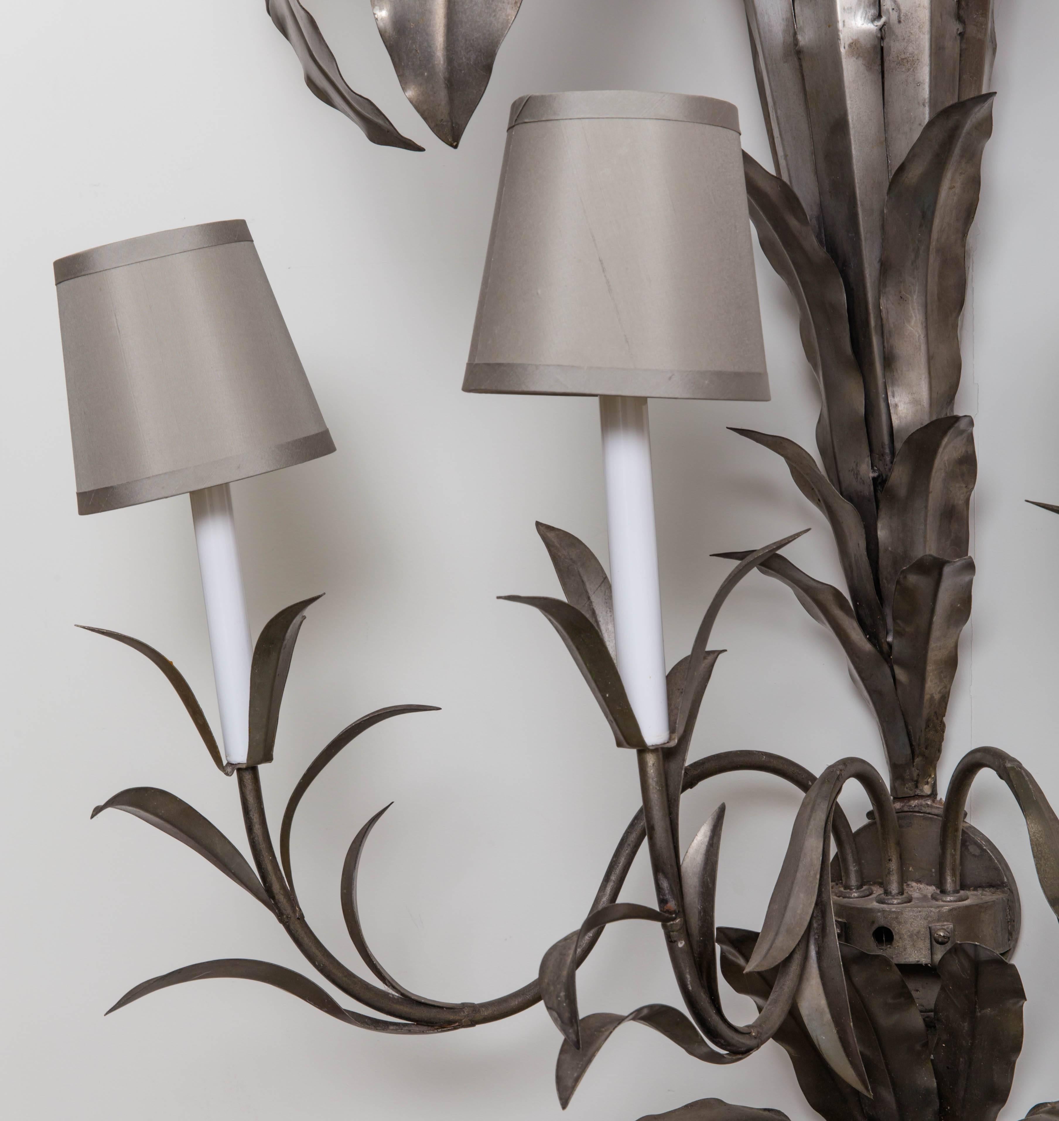 Stylized white metal palm trees, palm fronds with three arms that light.