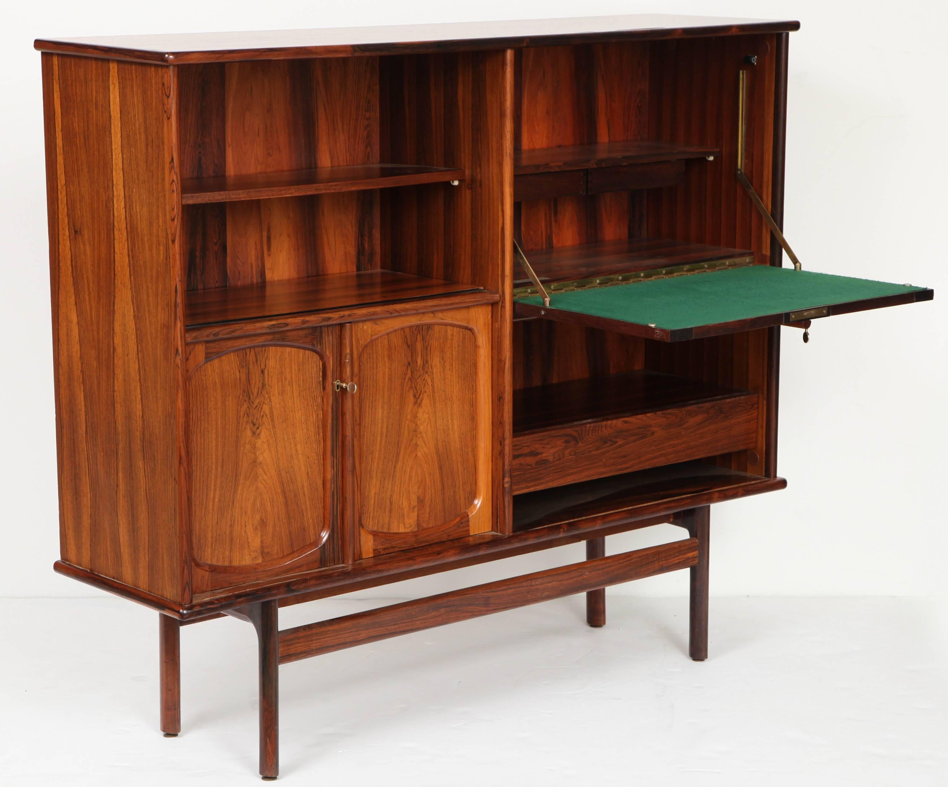 Modern lines in a rich rosewood 
the upper door pulls out to serve a writing desk. Inside it bears a chrome plaque with the name of the furniture designer,
this piece has various shelves and drawers.
Note on the image number 10, the exquisite