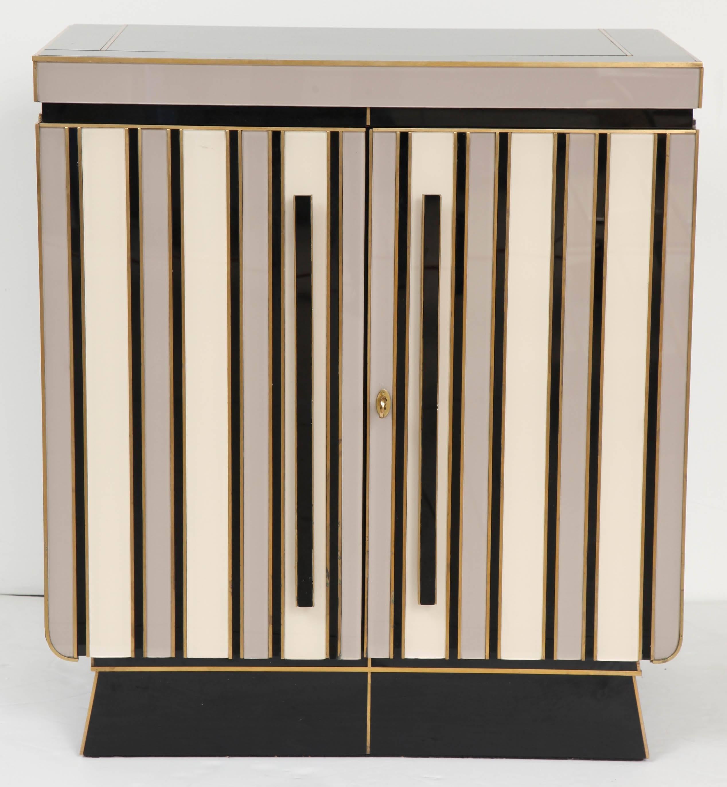 Unique pair of vintage Italian mid century nighstands.  These nightstands are made of wood covered in high gloss alternating black, light grey and ivory colored Opaline glass with beautiful bronze inlays and working brass keys.  These pieces were