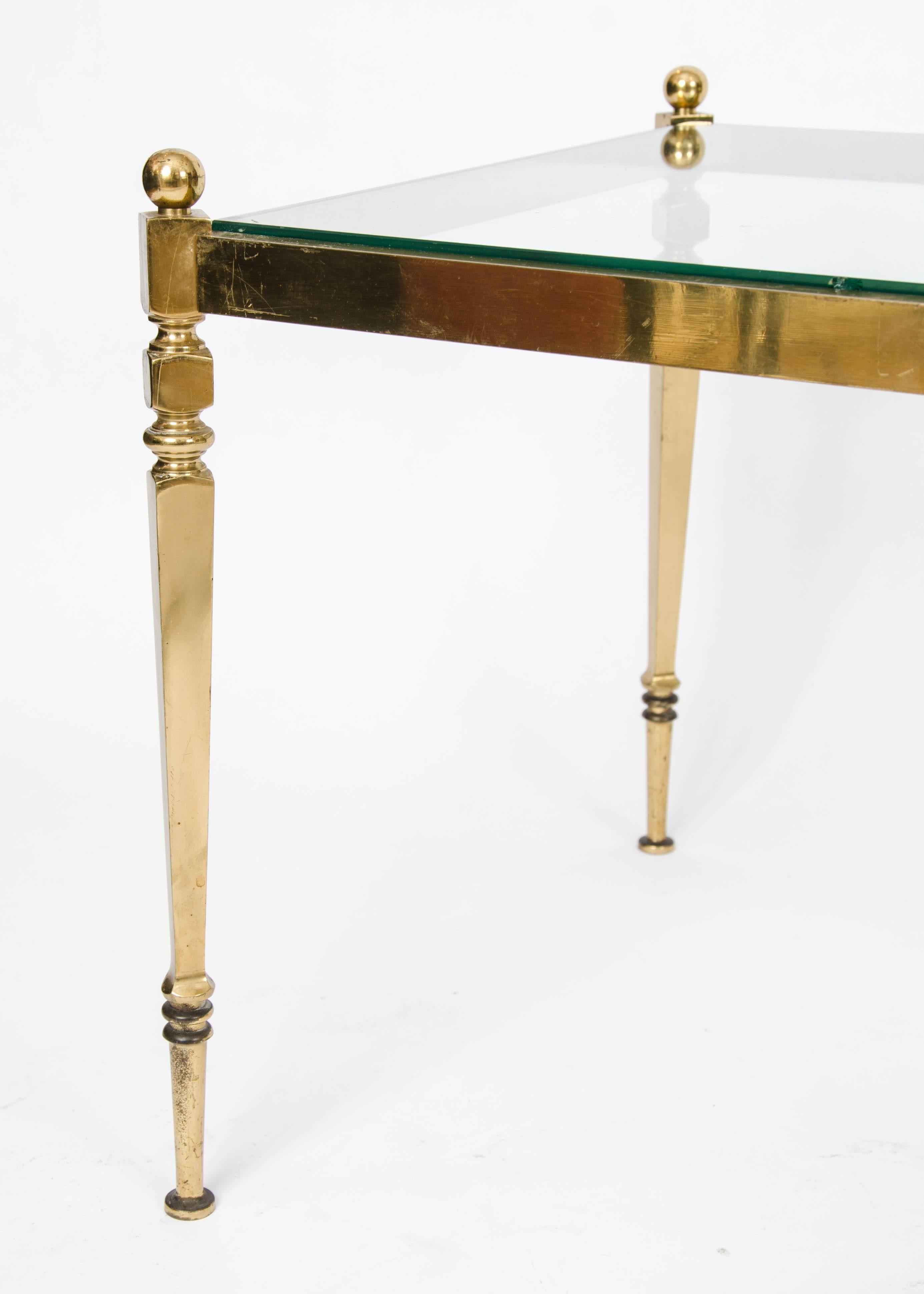 Pair of solid brass side tables with glass tops.