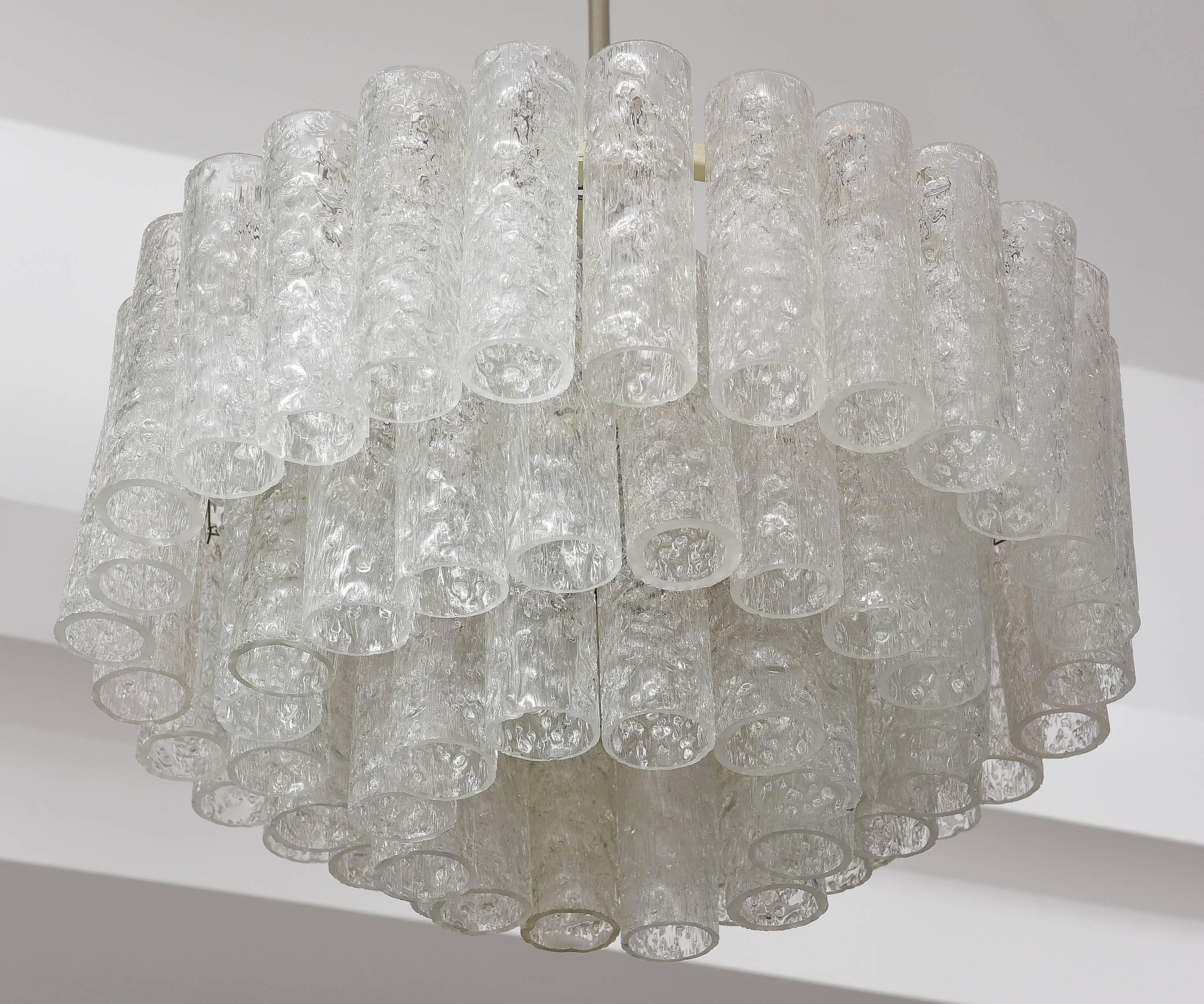 This amazing Mid-Century modern chandelier was produced by the iconic firm of Doria Leuchten of Germany in the 1960s.  The three-tiers of 60 tubular prisms are in what is called the "Eisglas" technique.

Note:  The main body of the