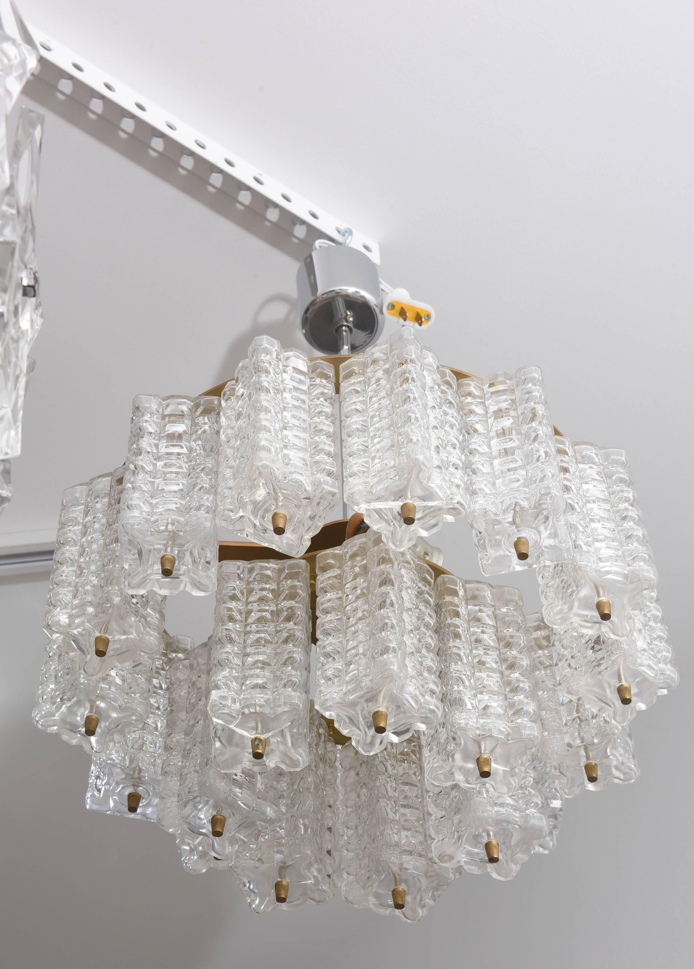 This mid-century modern chandelier is from the iconic firm Austrolux of Austria and was made in the 1960s.  There are 21 molded-glass prisms in a 