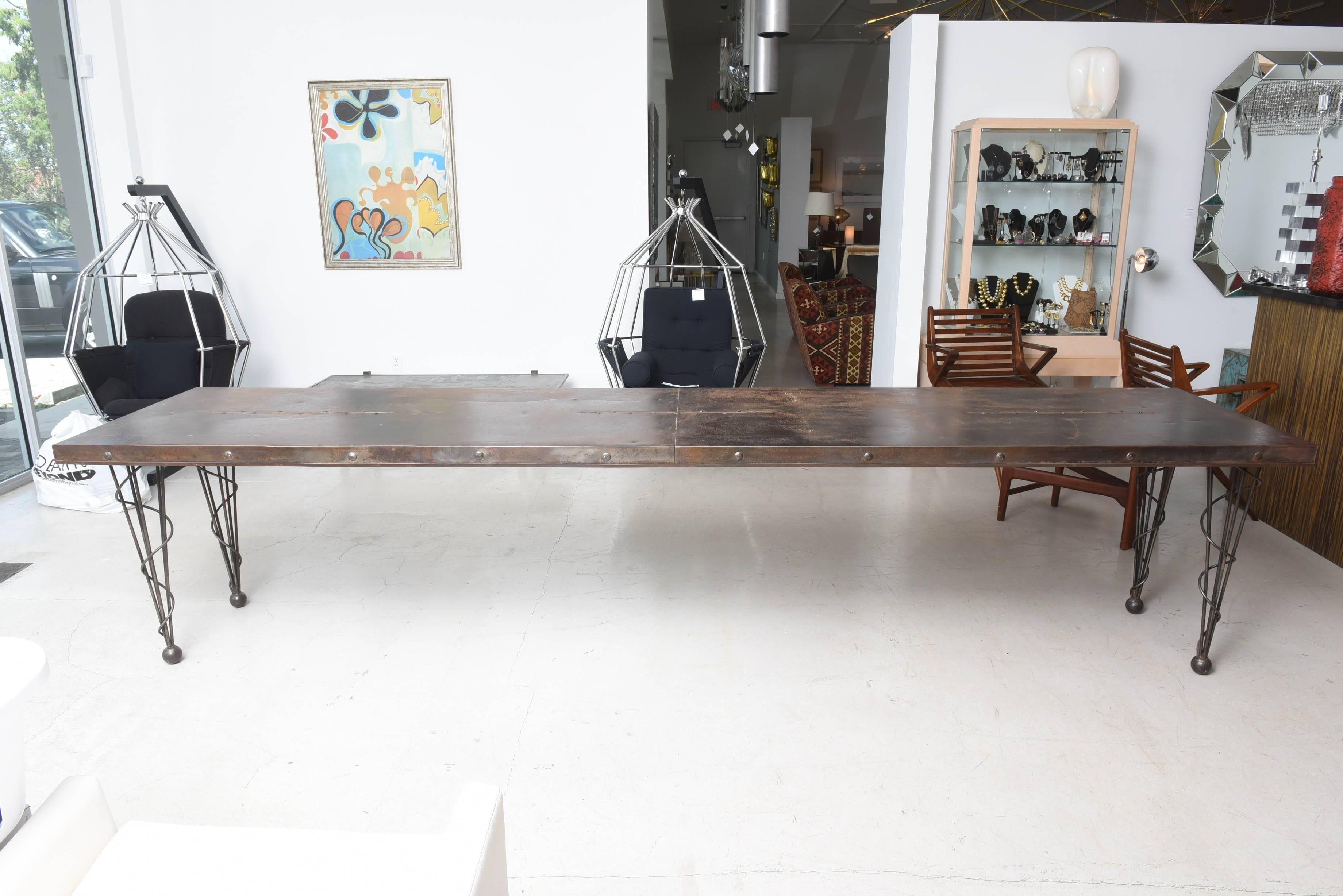 Twelve foot long factory table with whimsical conical legs. 