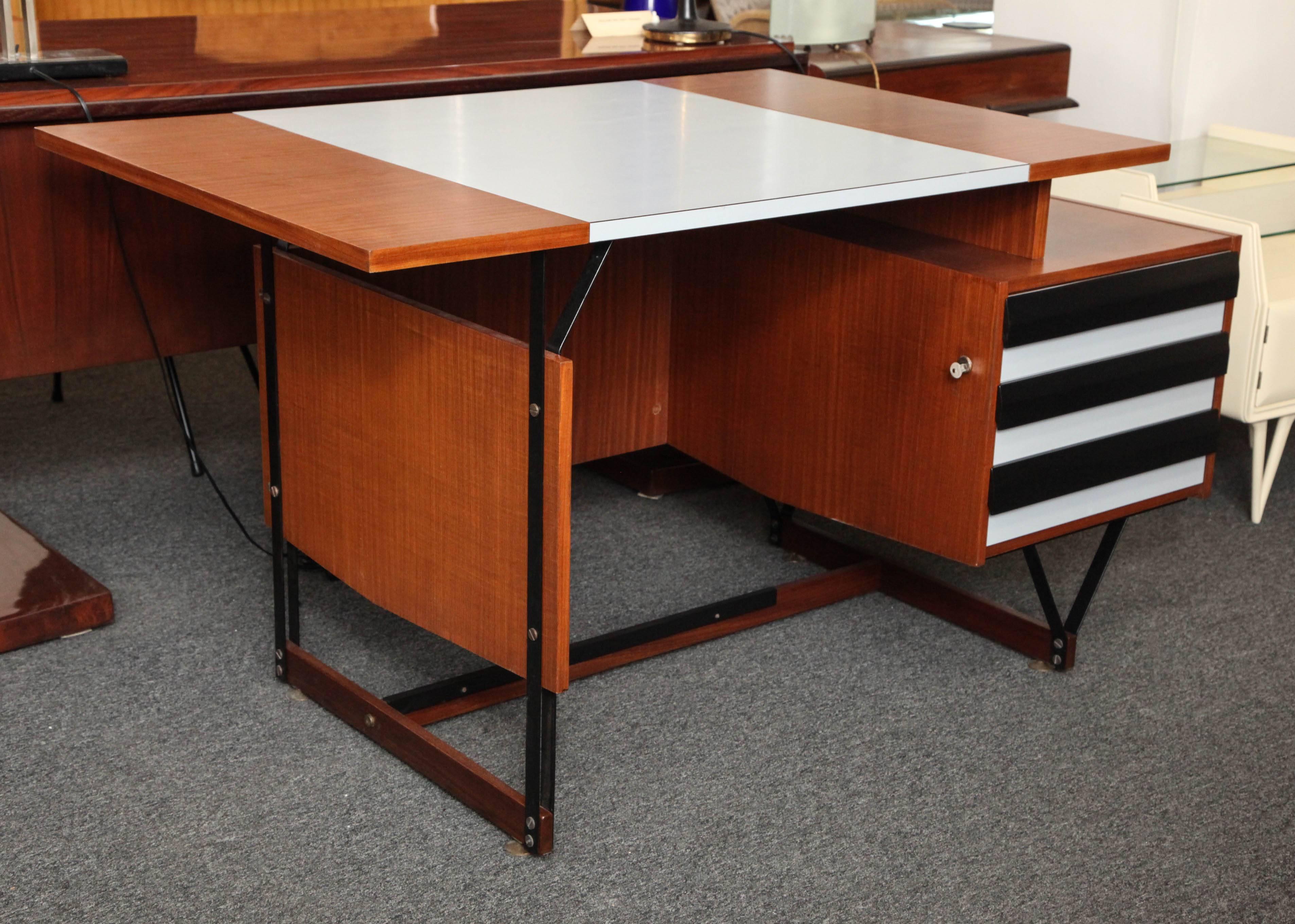 Exciting modernist desk made in Milan, 1955, unusual architectural form, mahogany with steel frame top in gray formica, key to lock the three drawers, nice size, great quality.
 