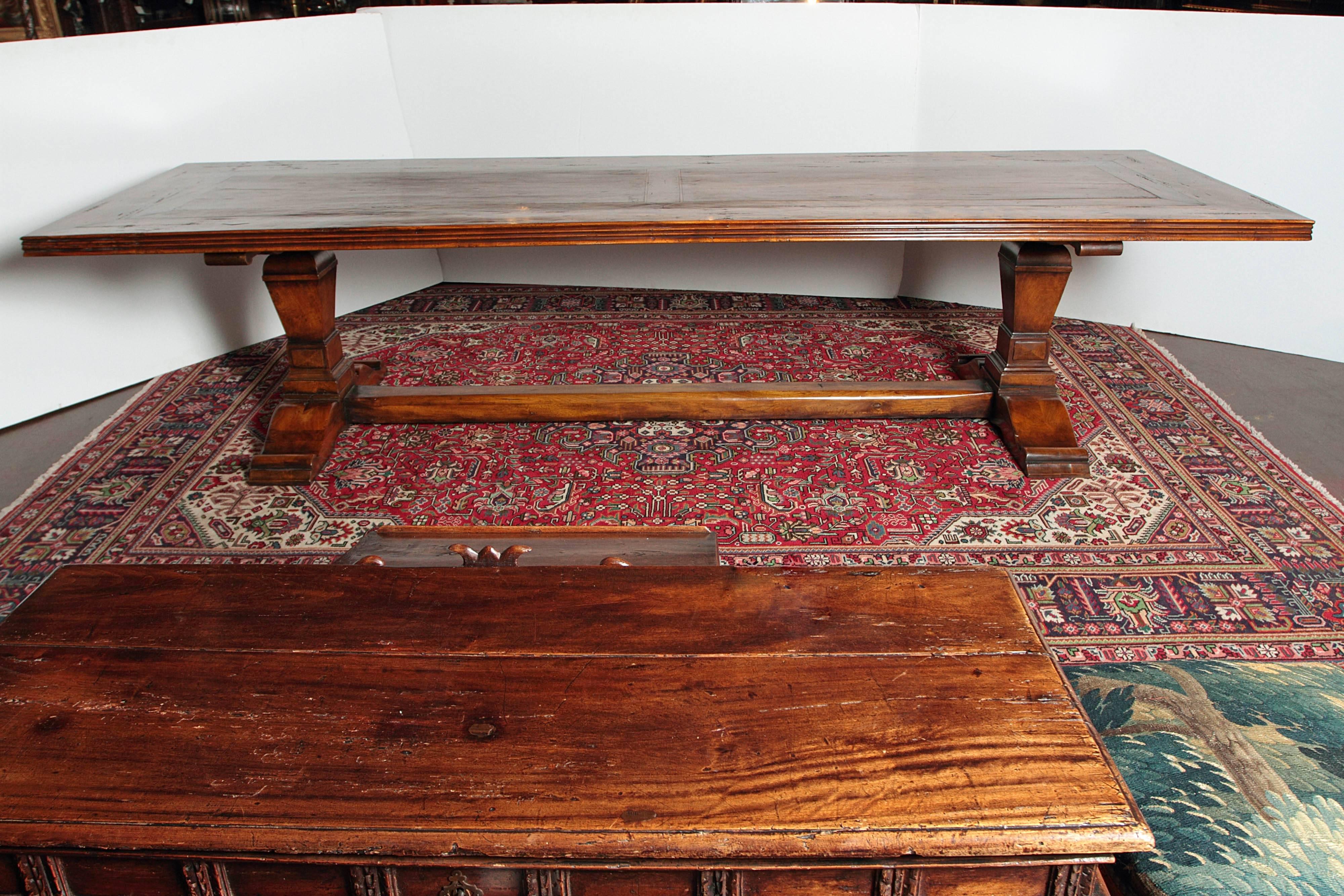 Long 19th century walnut trestle farm table from the French Pyrenees (circa: 1860). Two carved pedestals with a center stretcher support the large top with has inlays bands all around. Will seat 10 to 14. Some restoration. 
