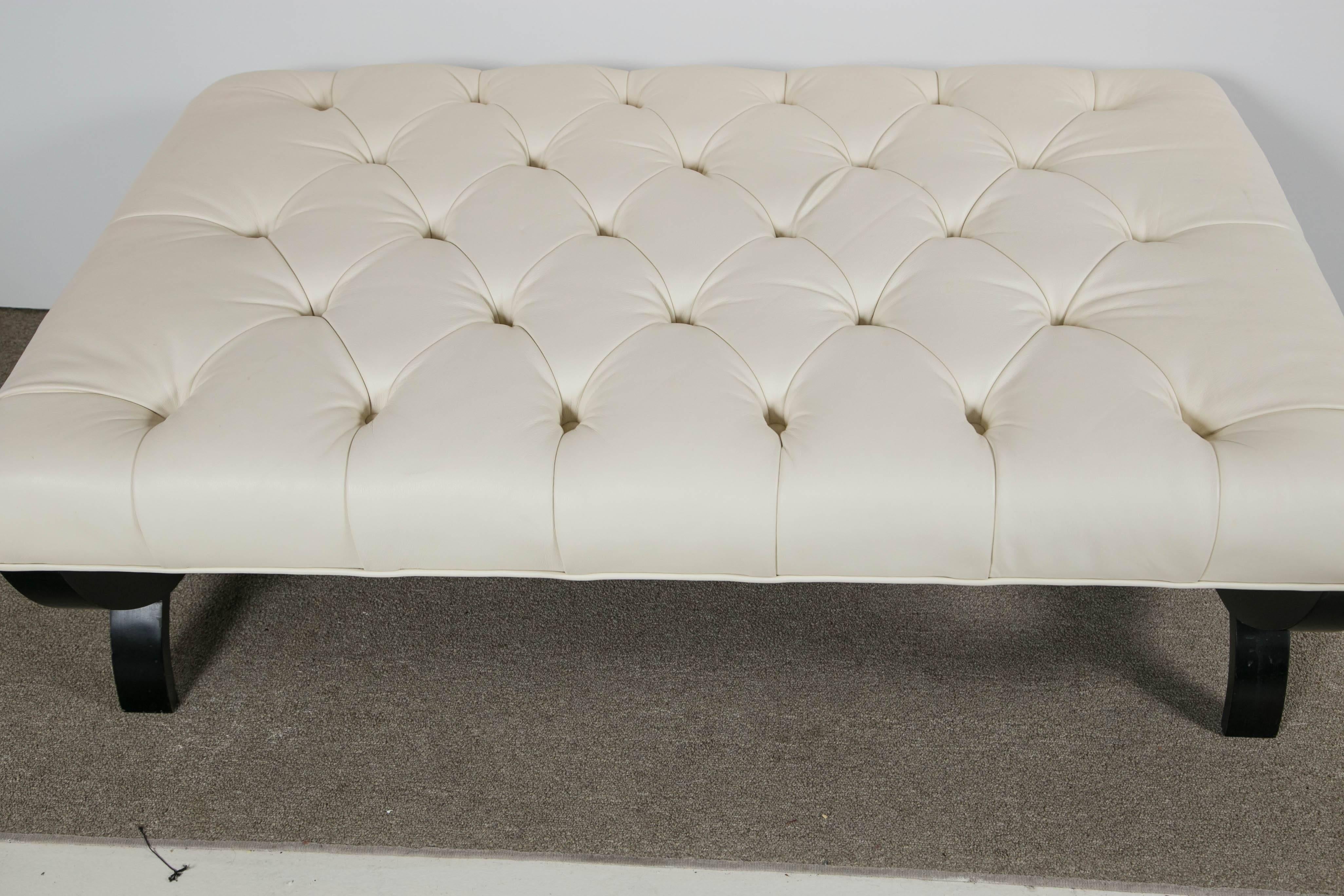 Directoire style tufted ottoman by Thomas Pheasant for baker. Newly upholstered in white leather with ebonized base.