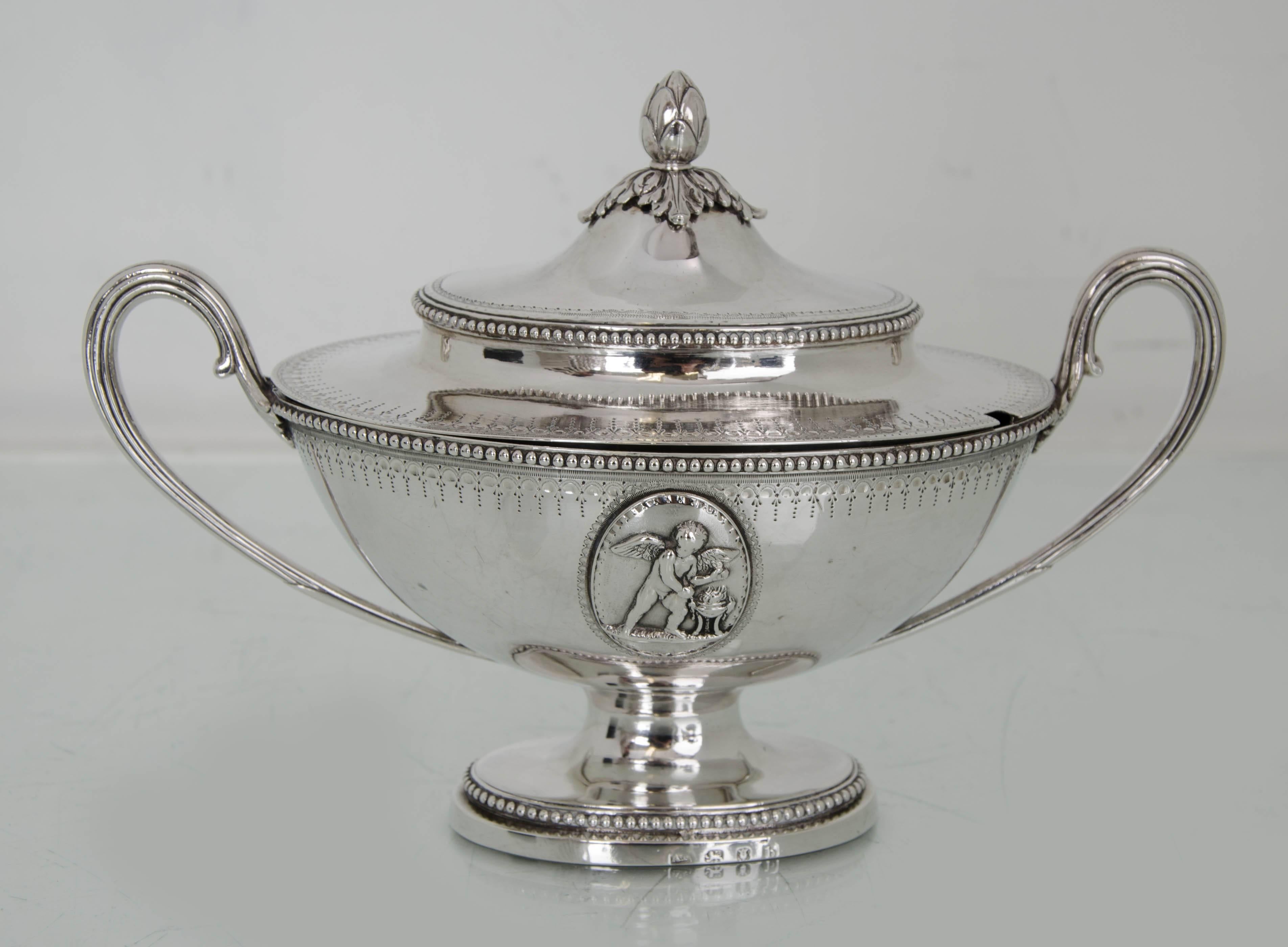 Suite of four 18th century silver sauce tureens London 1777 Andrew Fogelberg

A suite of four beaded sauce tureens with single scroll handles. The sauce tureens benefit from bright cut engraving and applied oval plaques depicting cherubs. The