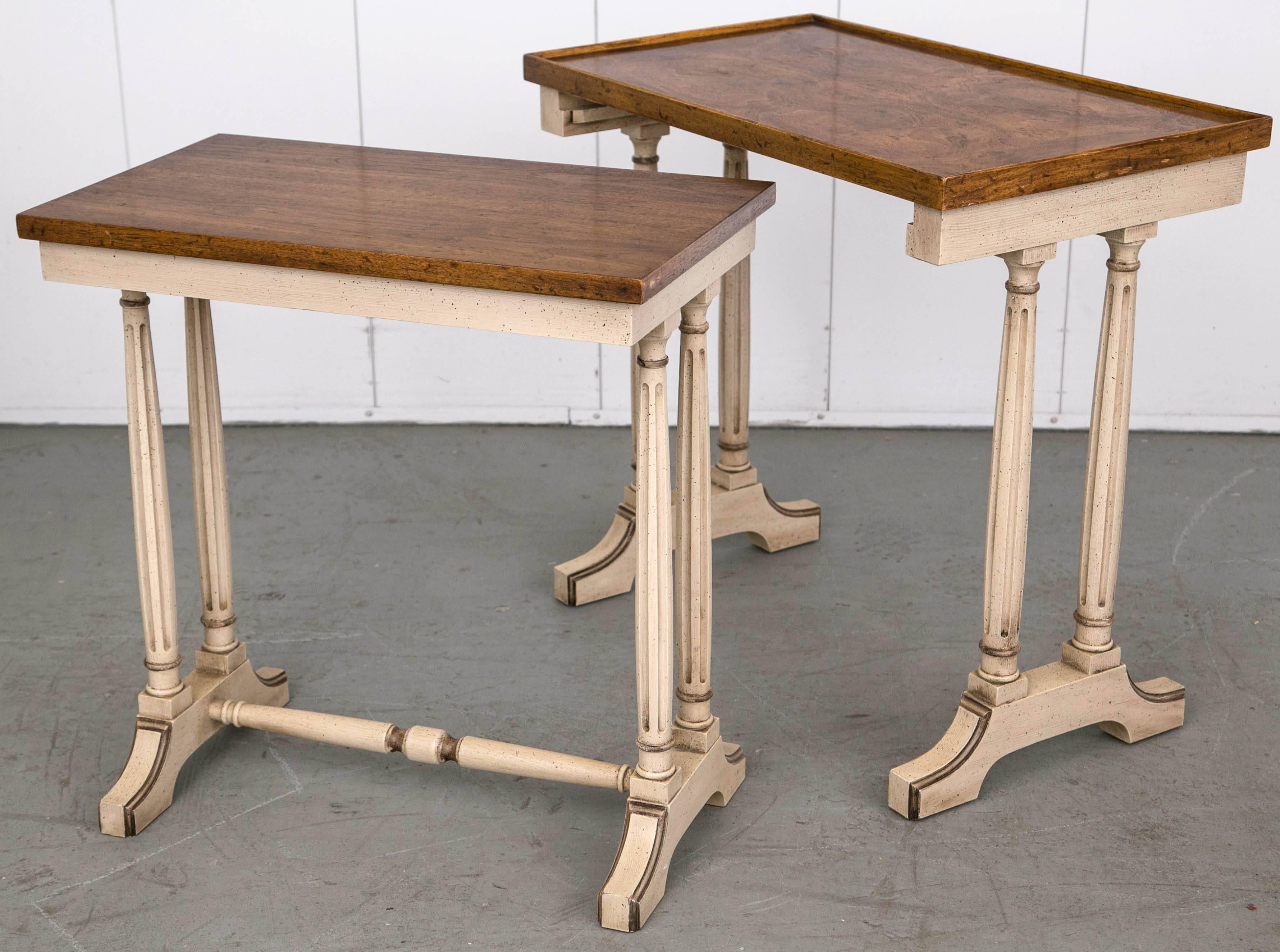 A set of two nesting tables, the lower able to slide in place beneath the upper.