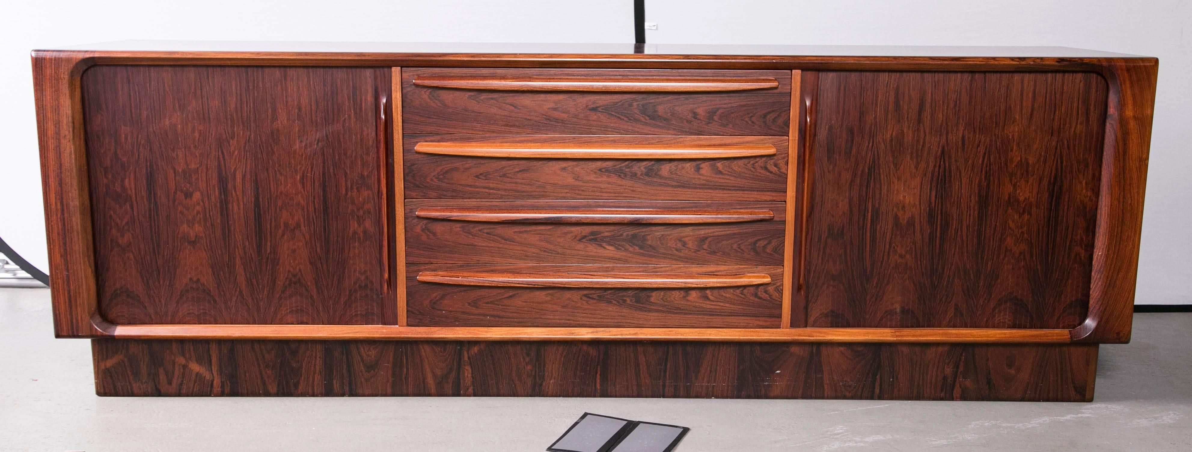 A Danish modern platform base credenza with drawers and shelving behind sliding doors. Produced by Dyrlund of Denmark for Maurice Villency NYC.