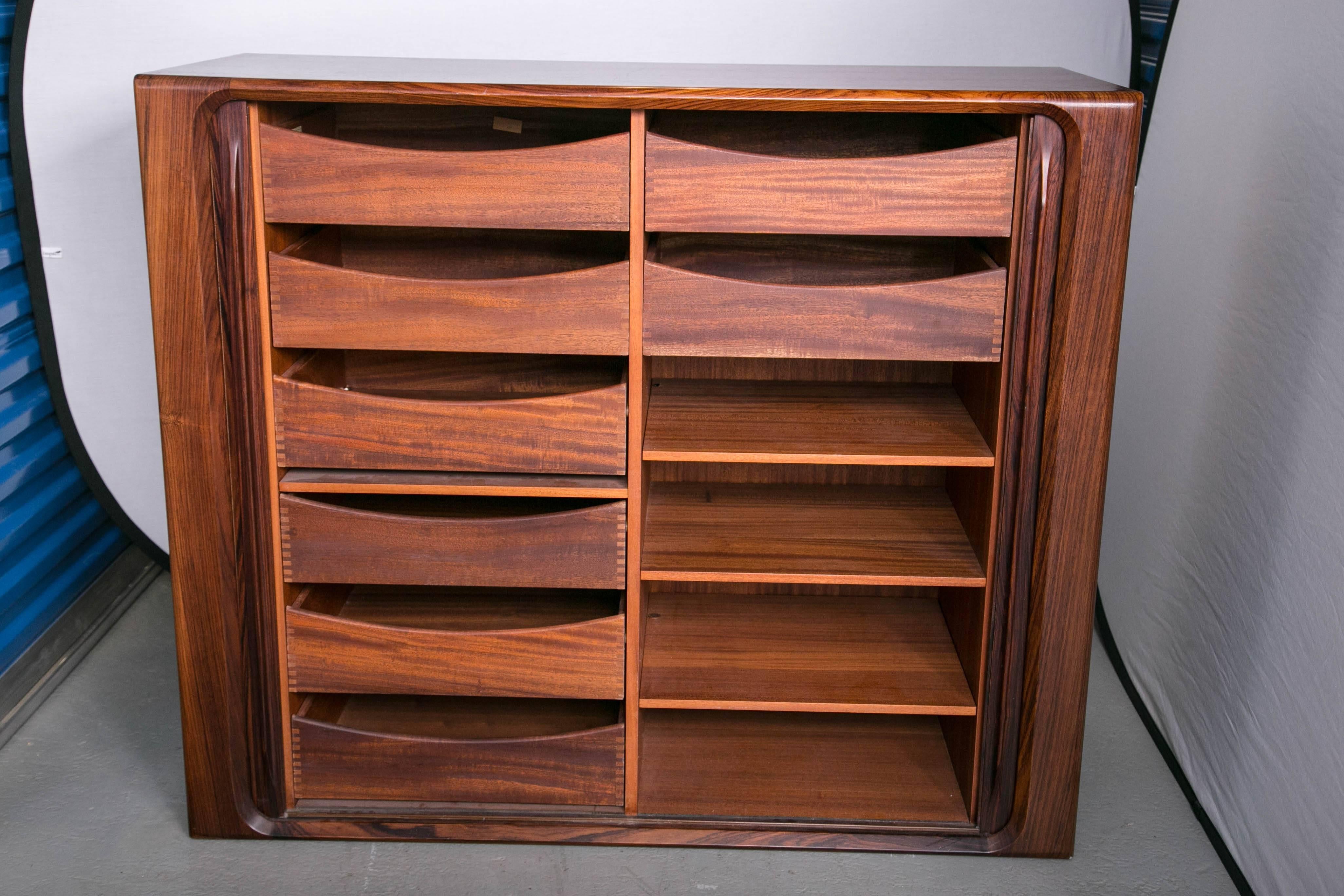 A sleek Danish modern design rosewood cabinet with both drawers and shelving. Made by Dyrlund of Denmark for Maurice Villency.