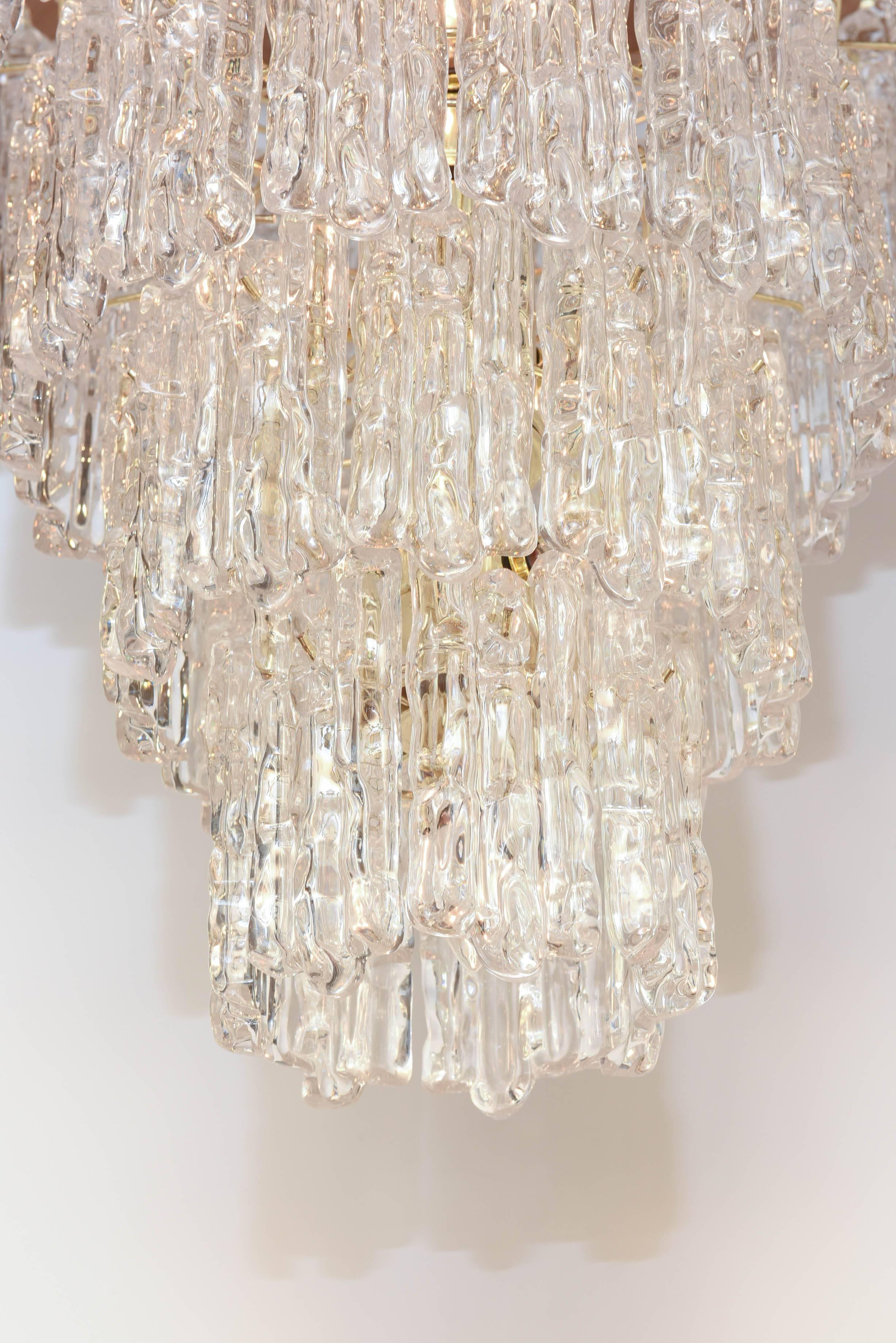 Italian modern five-tiered waterfall style chandelier, by J.T. Kalmar, having a brass frame, suspending "ice" prisms, of Lucite.

Stock ID: D6968