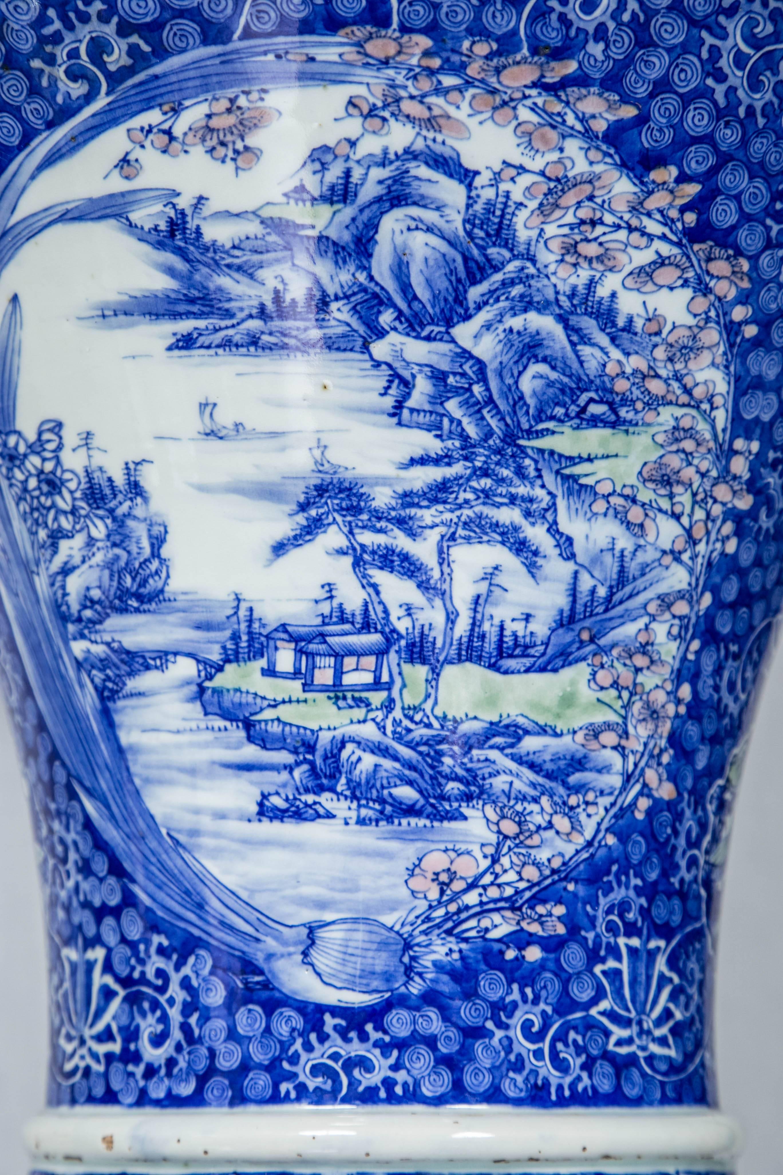 This tall vase has been professionally restored at two cracks. It is beautifully hand-painted with animals, bird, butterflies, natural scenes, flowers, fruits and Japanese decorative motifs. Formed with a wide, undulating mouth, narrow neck and