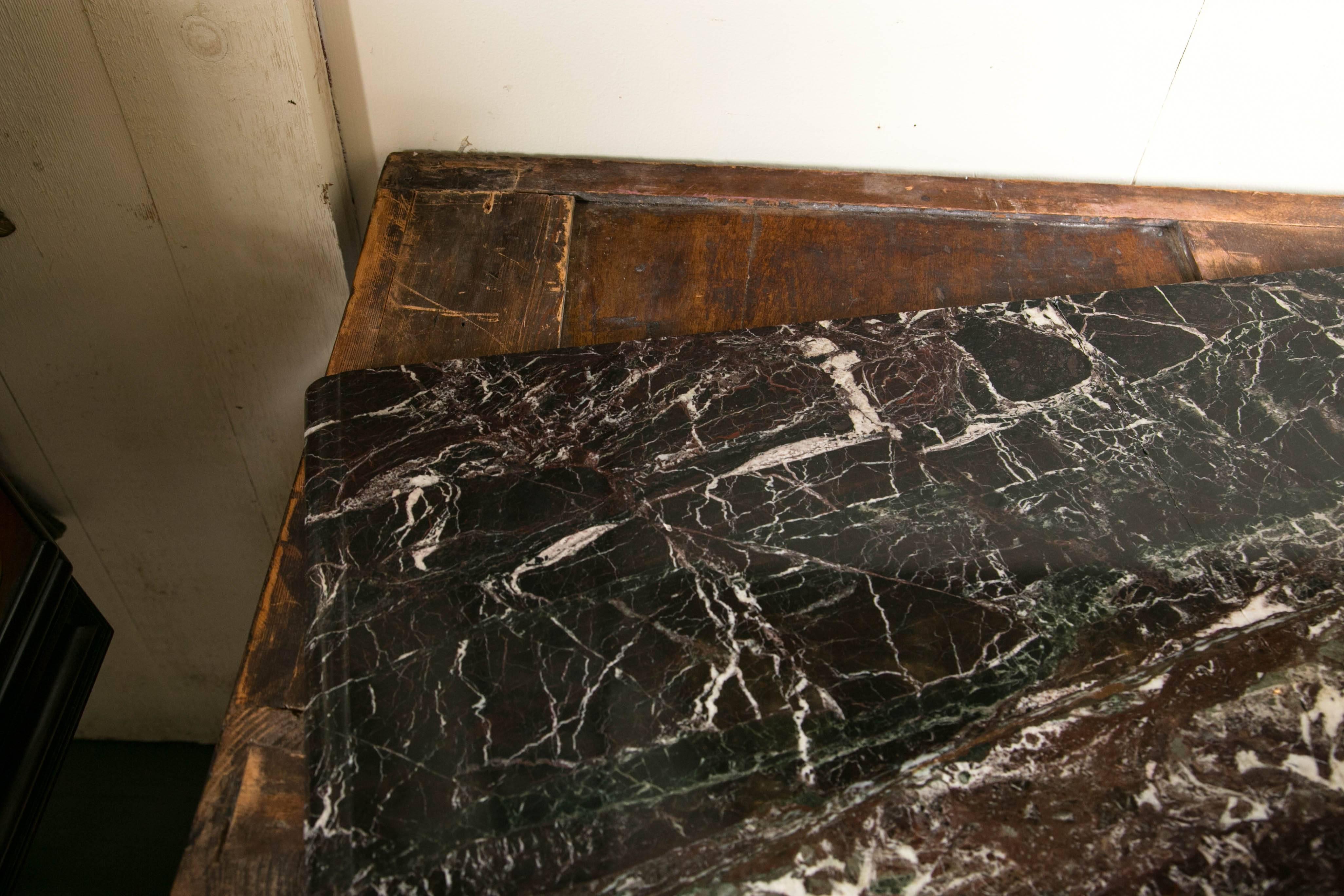 The marble top not original and repaired. The commode of bombe shape with parquetry veneers covering the front and sides. Gilt bronze handles and cap feet but only on the front legs. The commode was probably made in Genoa, Italy.
On the upper right