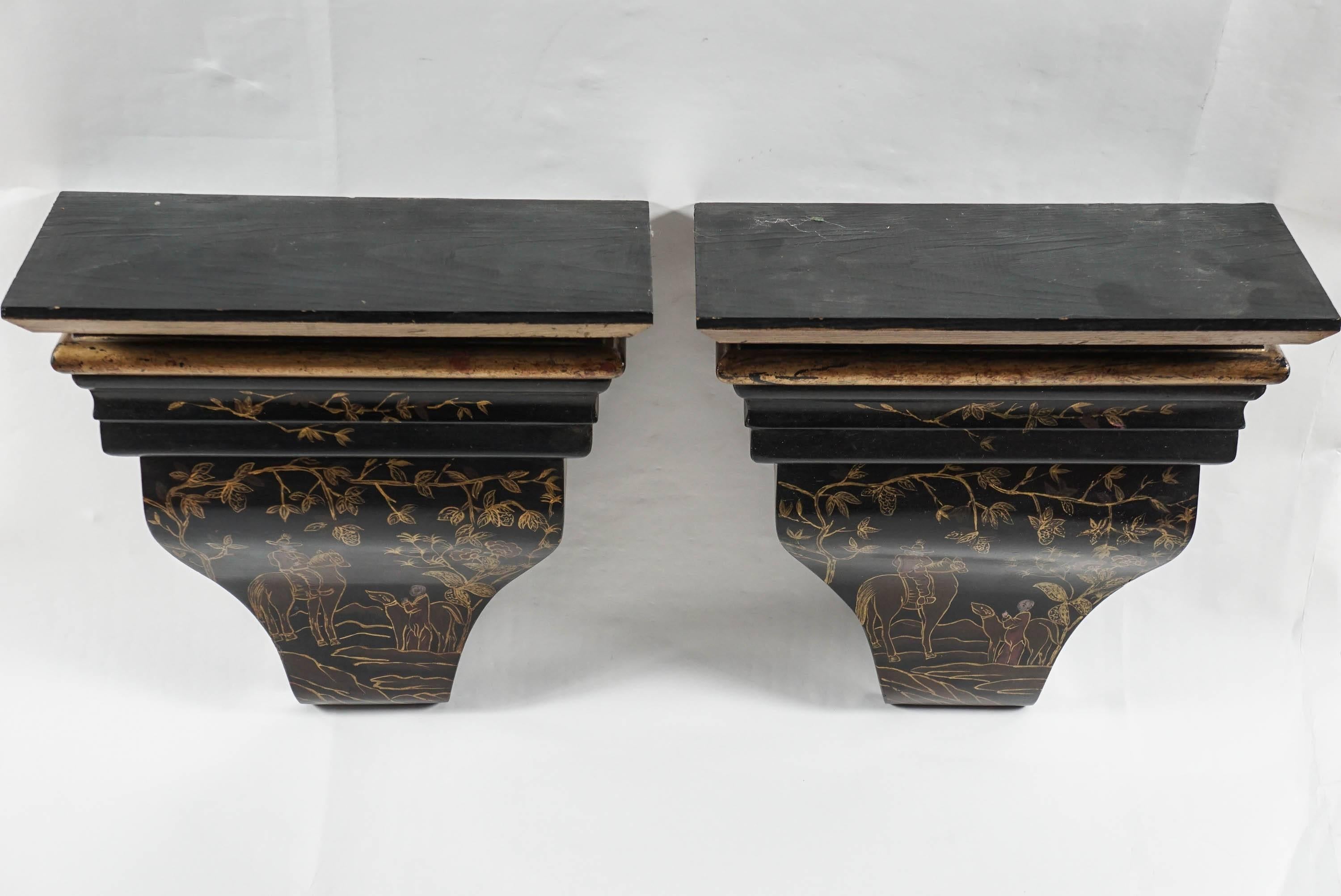 Pair of 20th century Asian black and gold painted wall brackets.