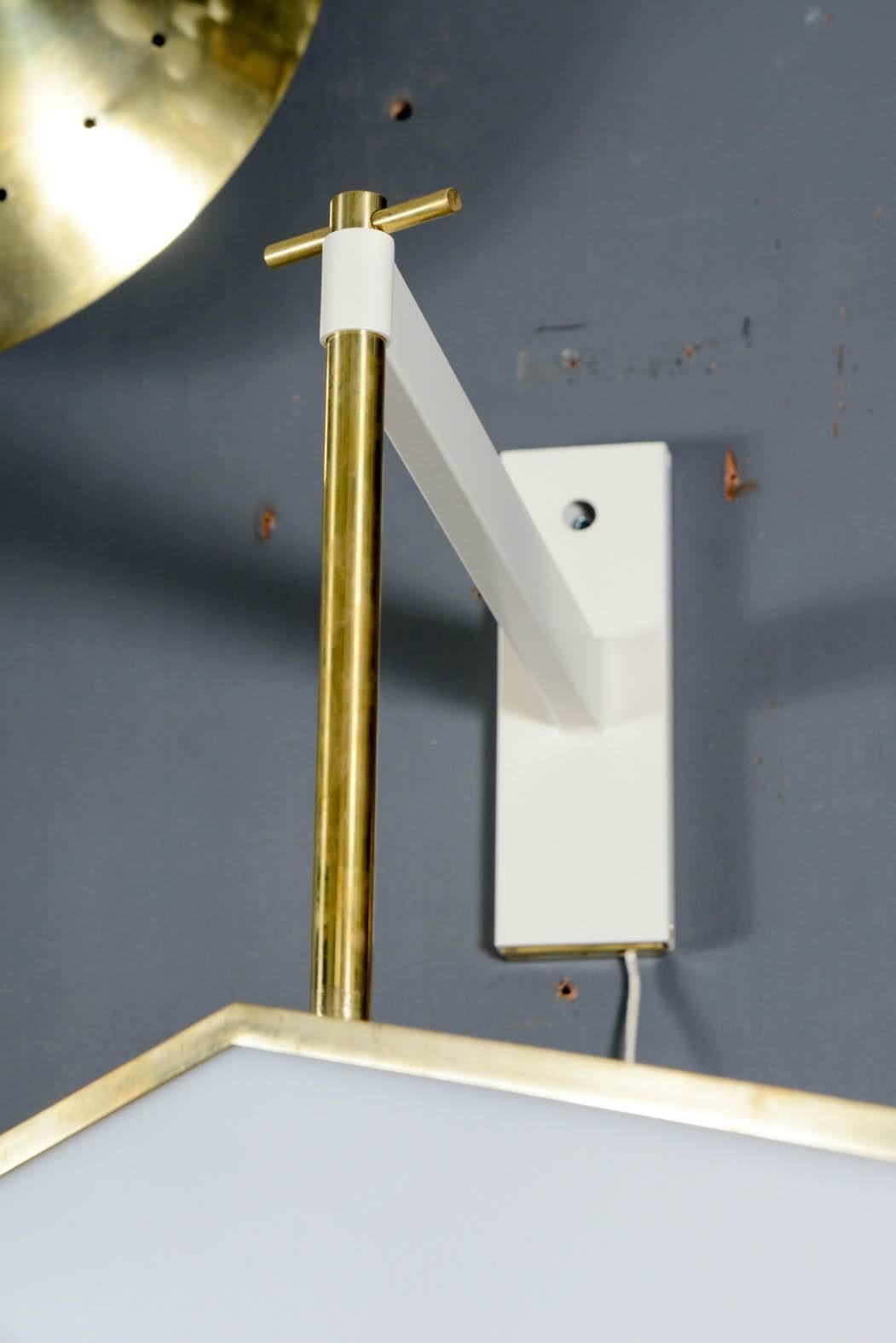 Exceptional wall sconces realized by Diego Mardegan.
White enameled structure holding a brass sconce with perforated metal sides and plexiglass panels.

Signed by the artist, new electrification, perfect condition.