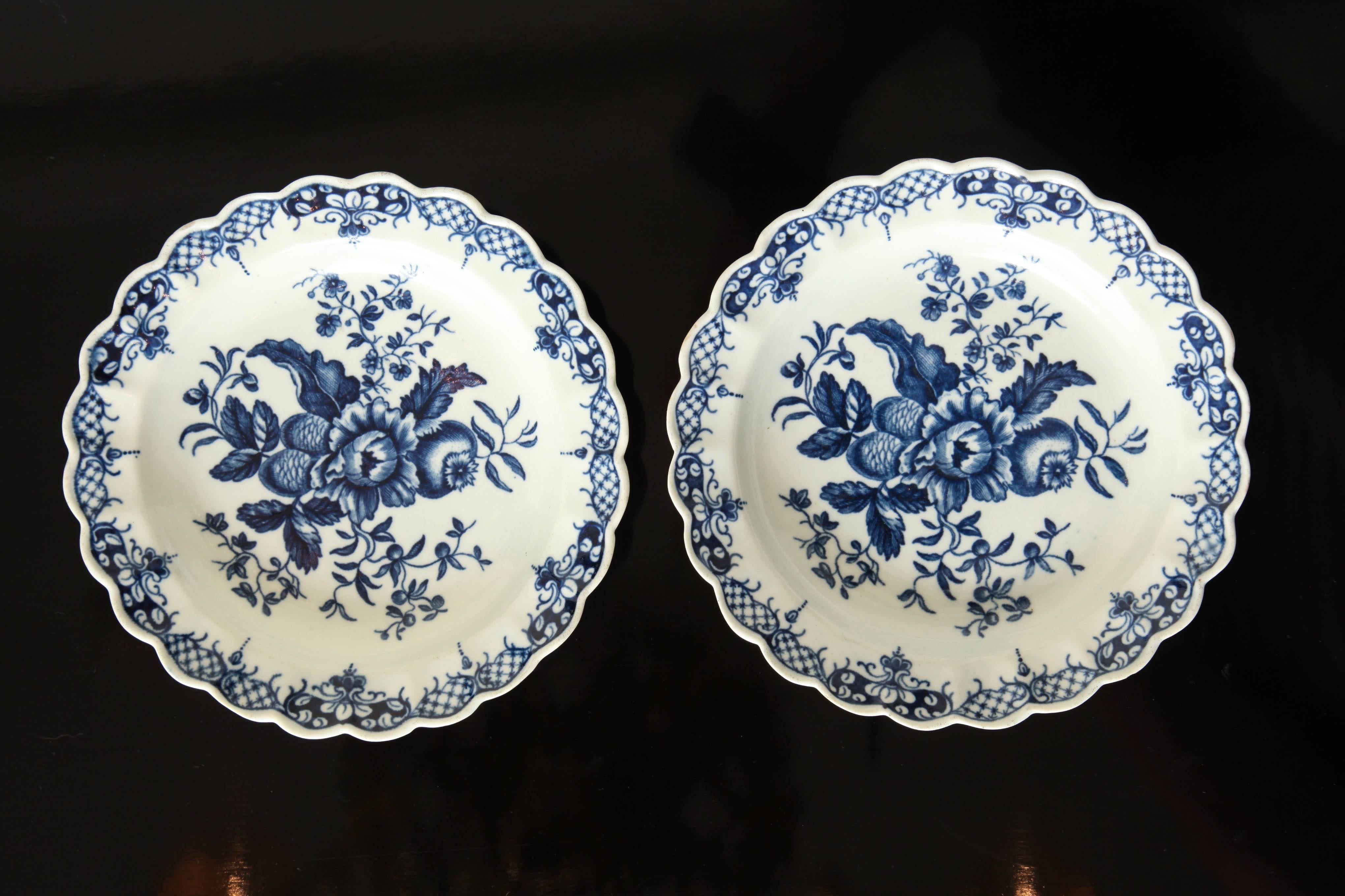Each with scalloped rim decorated with Rococo style diaper work with reserve centered by pine cones and floral sprays. Bearing Worcester crescent mark on underside.

  