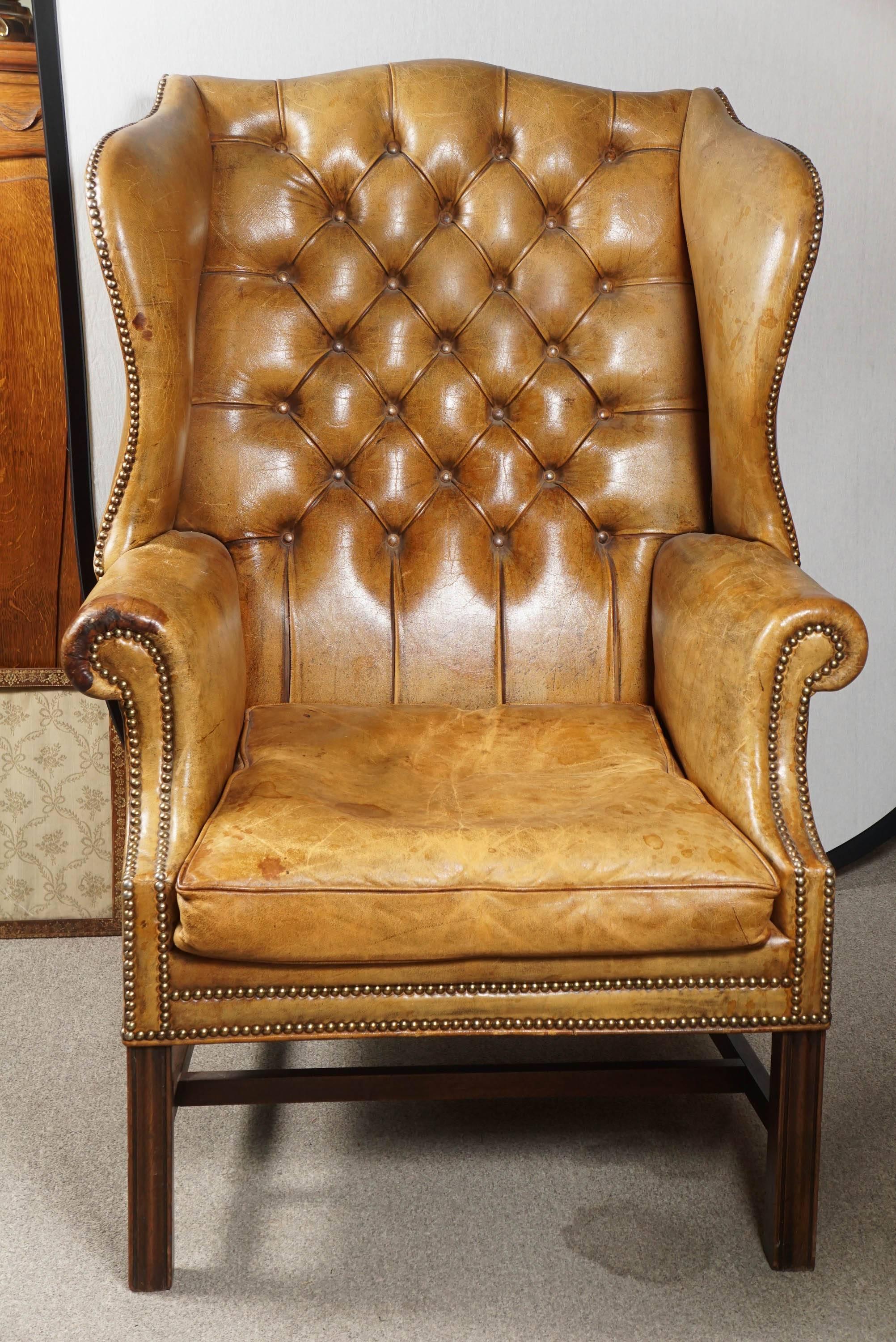 Tufted leather wing back chair. George III style