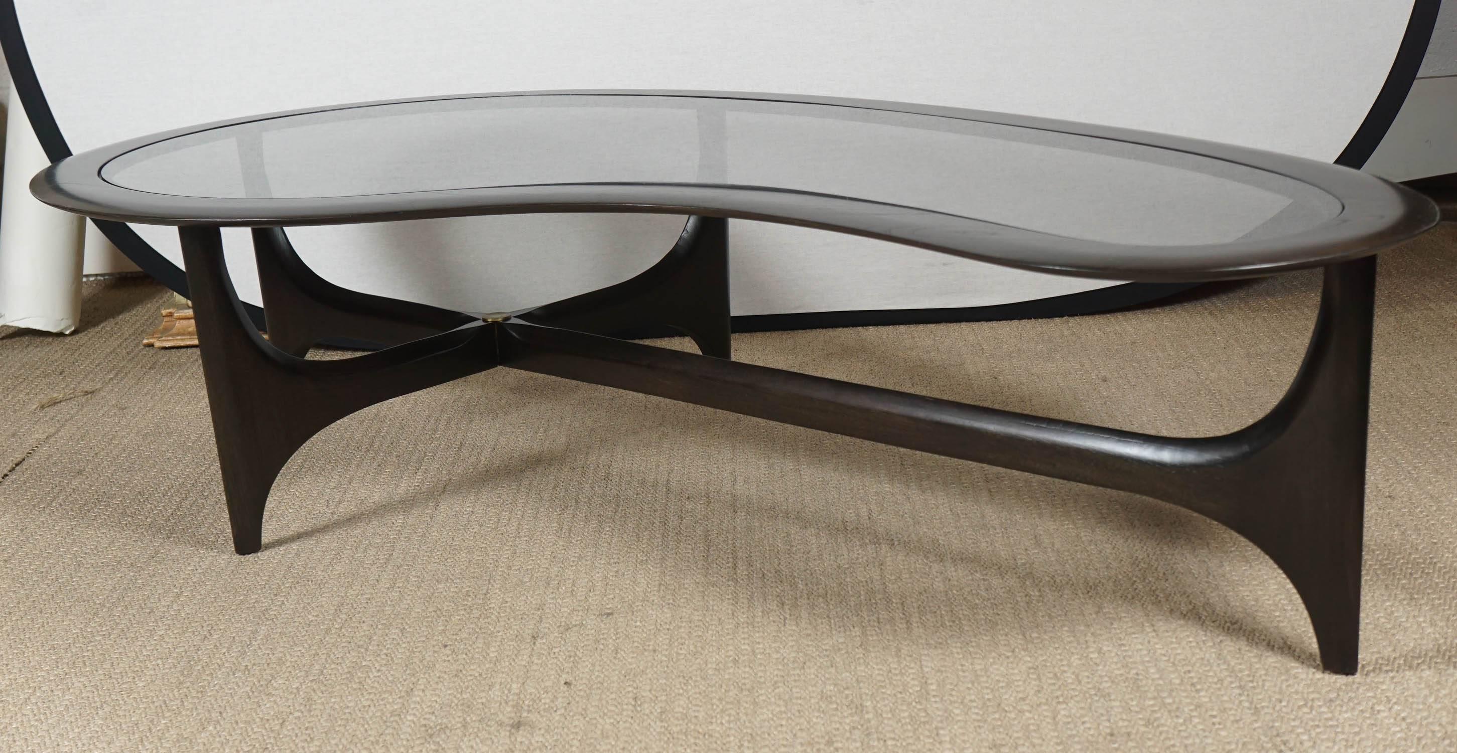 Here is a great boomerang coffee table in an ebonized black finish with a smoked glass top. The stretcher has a rosette medallion center.
The table is by Adrian Pearsall and has a new finish.