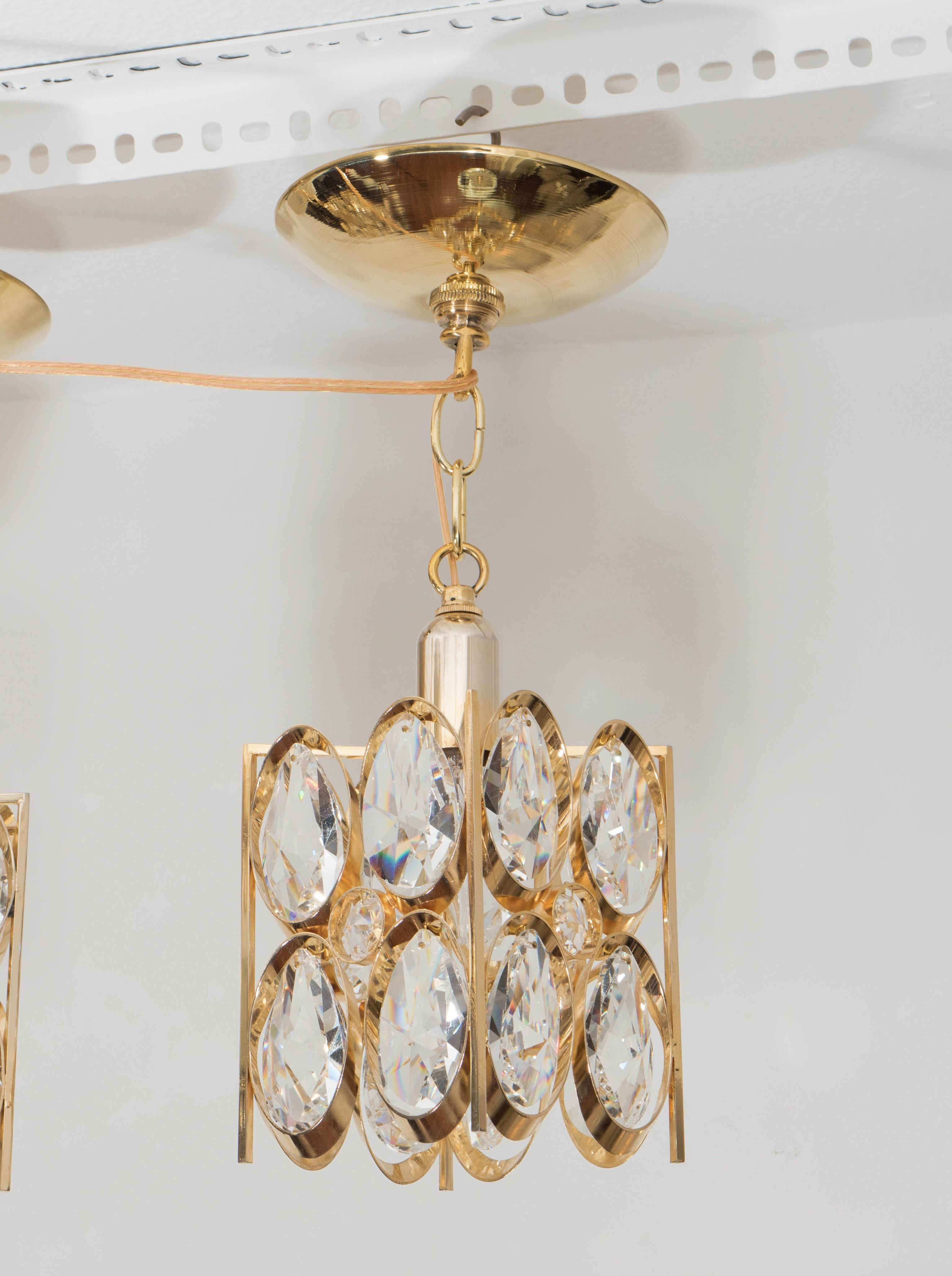 Petite brass pendants with inset facet-cut crystal teardrop elements.