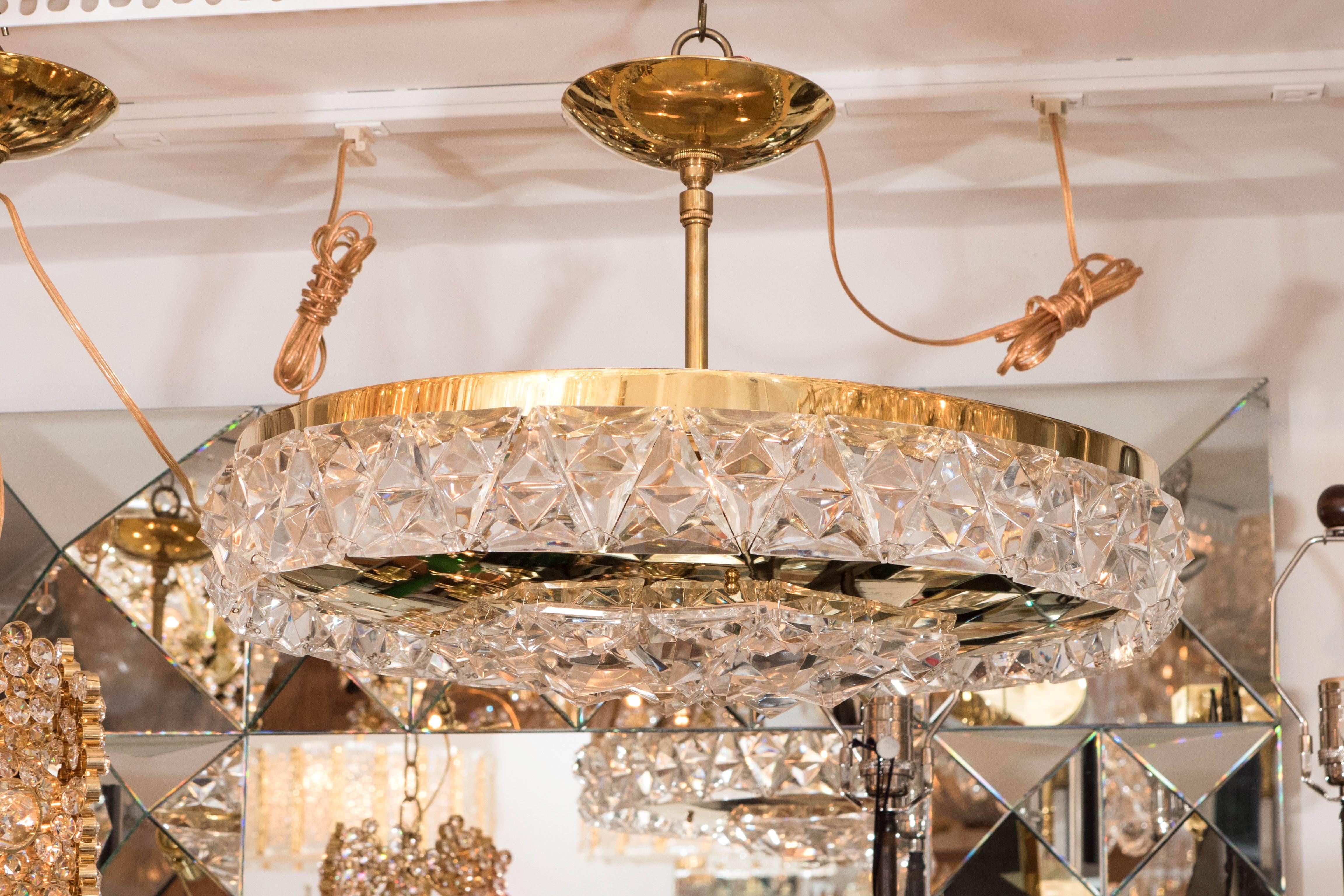 Round, polished brass ceiling fixture featuring a facet cut crystal element surround.