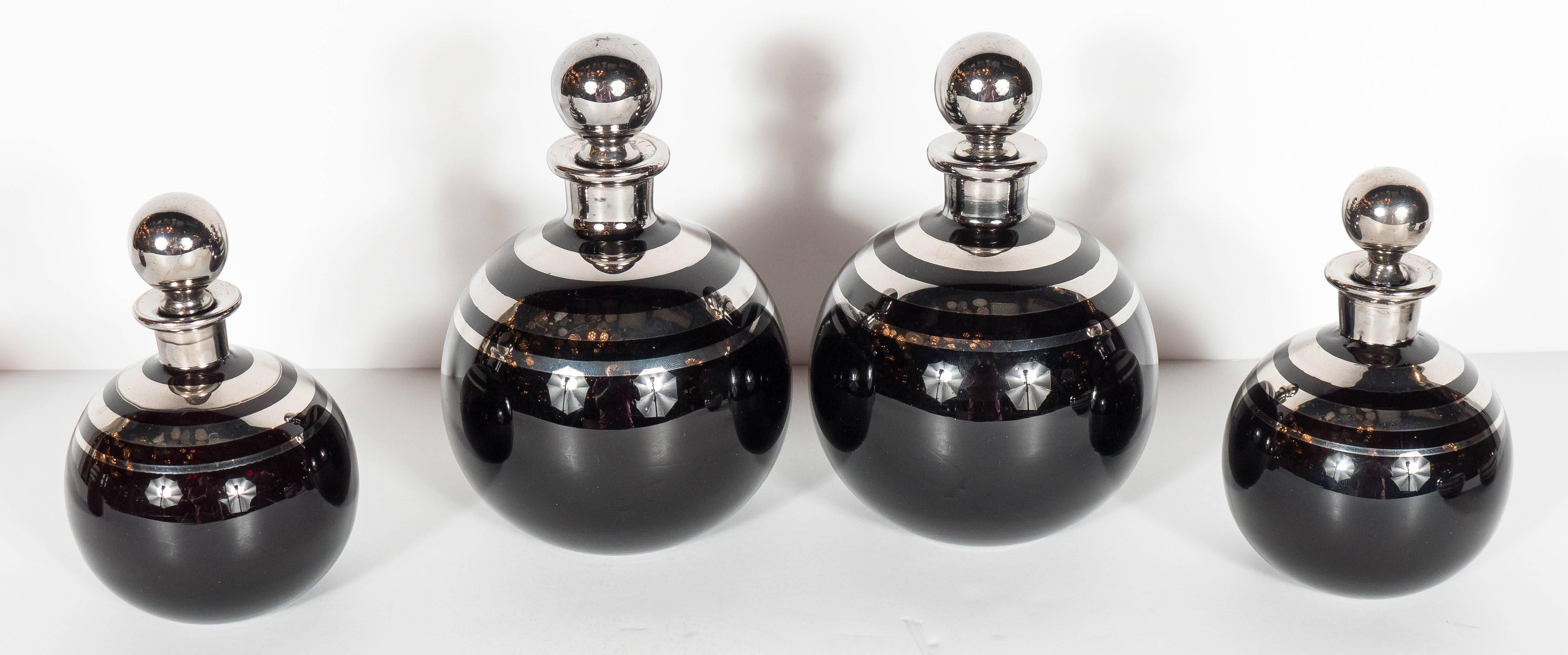 This incredible and complete vanity set is made of dark amethyst glass with concentric banded sterling overlay. It features four perfume holders, a covered box and dish both perfect for jewelry, it also has a cup as well. These are all in incredible