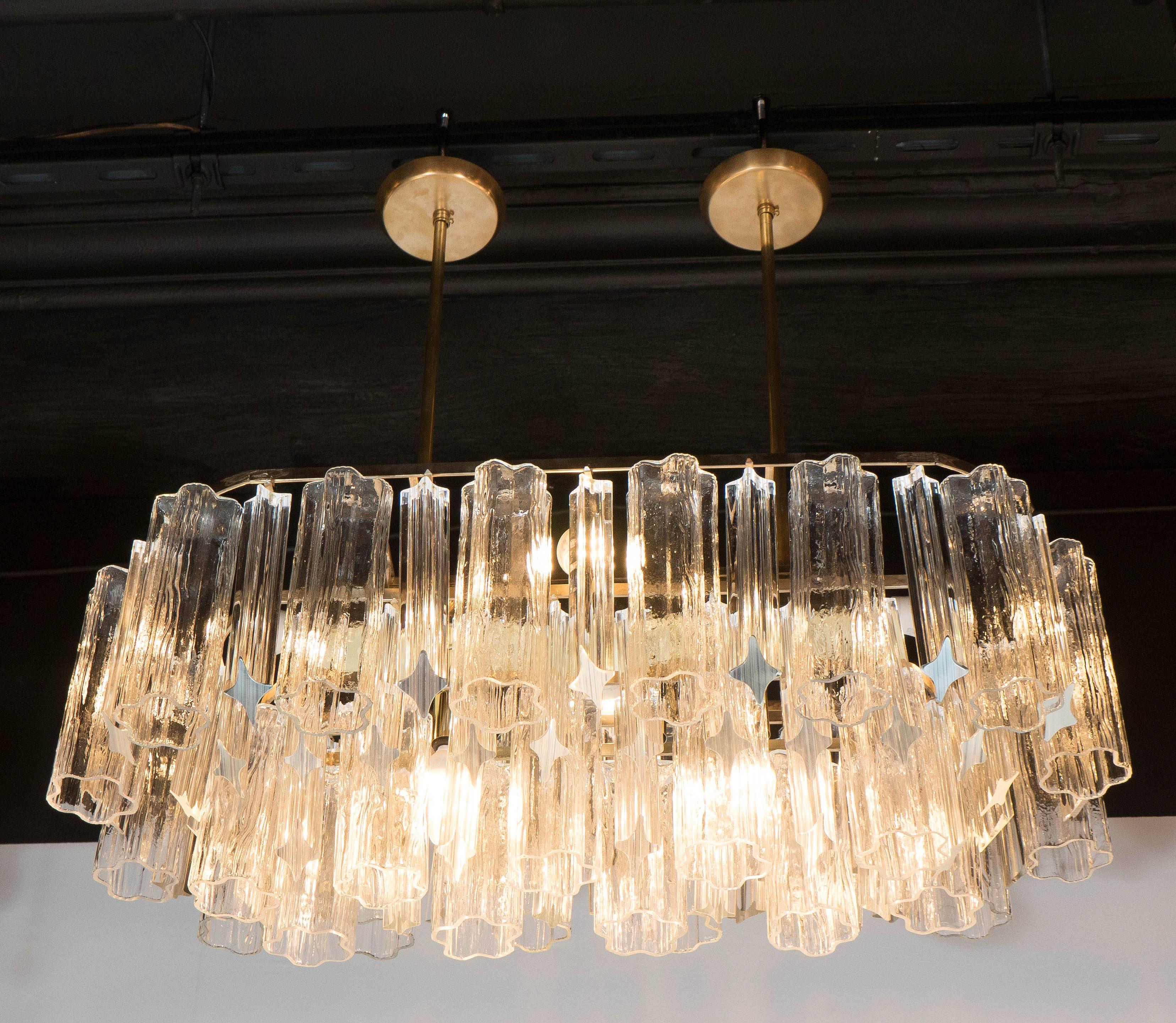 Two tiers of interchanging tronchi and angle-cut triedre crystals make up this wonderful and rare Murano chandelier by Camer. A polished brass frame with two rods supports the structure. The total height can be adjusted to suit. It would live very